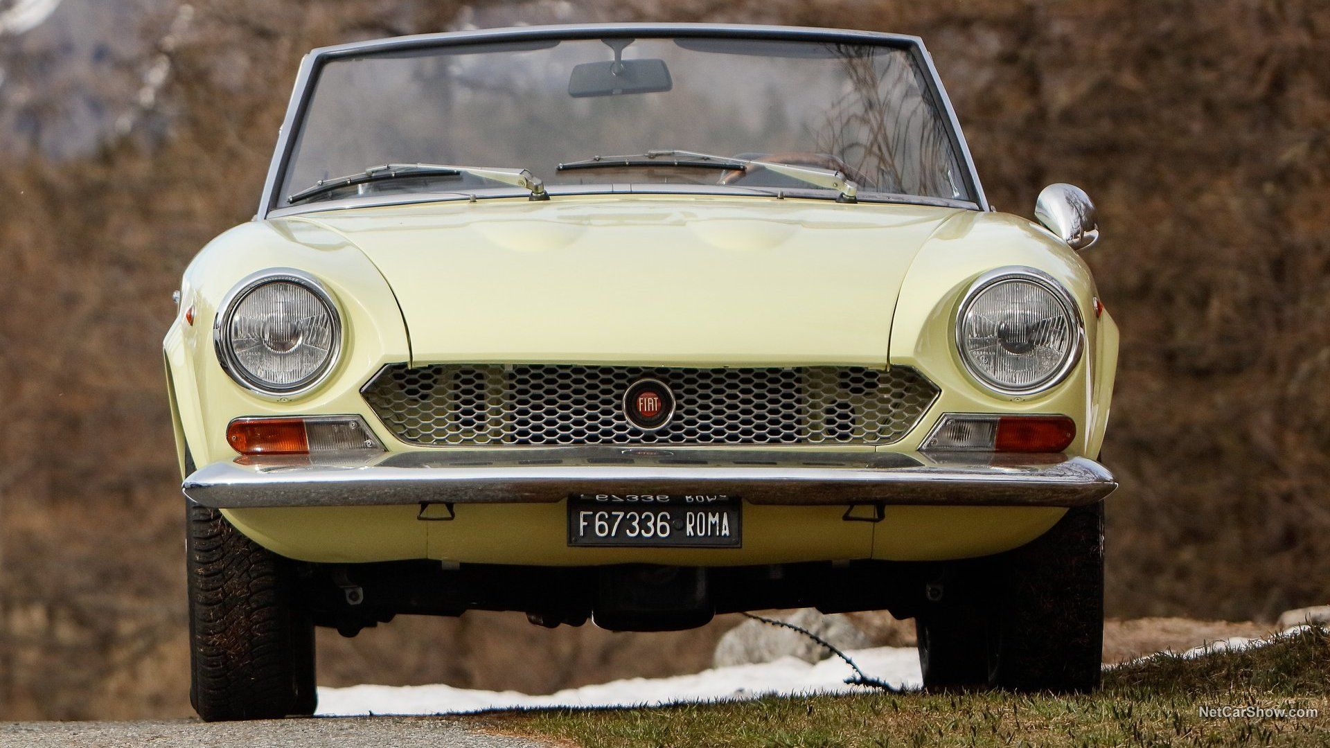 Yellow Fiat 124 Spider 1969 convertible with roof down - front view 