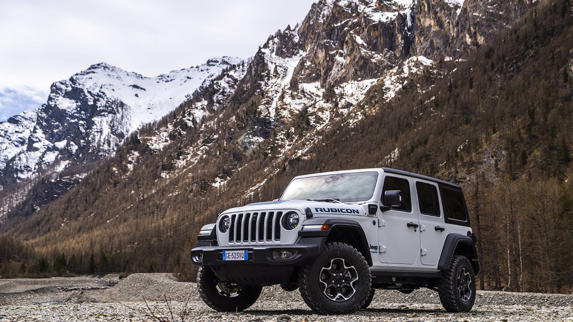 2023 Jeep Wrangler 4X Rubicon - vista frontal e lateral esquerda - branco - montanha e campo ao fundo