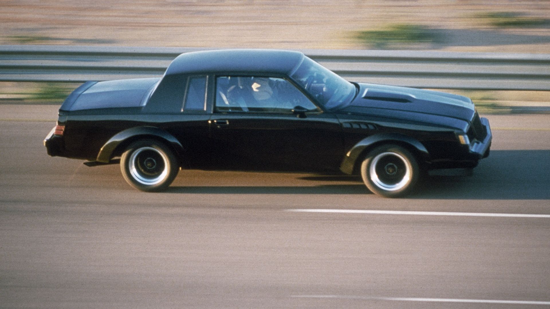 Buick GNX preto 1987 em movimento de alta velocidade em uma rodovia 