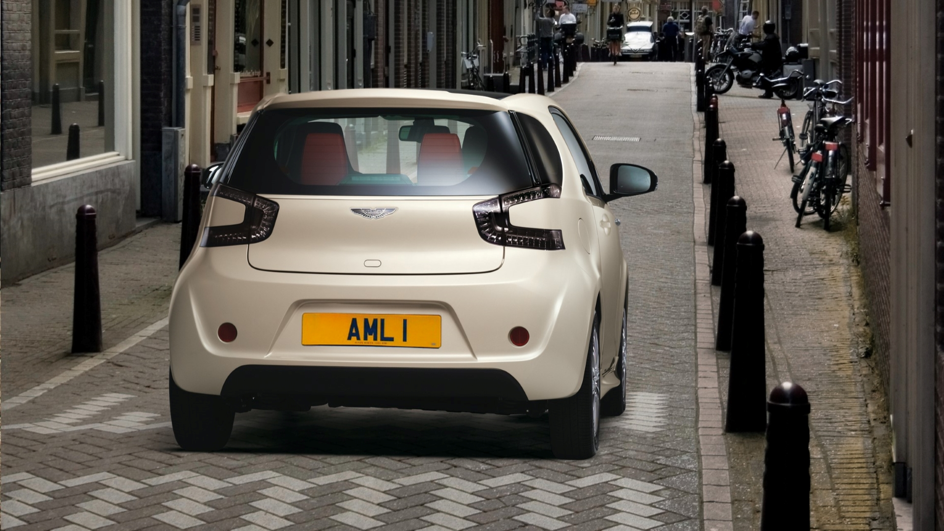Foto traseira do Aston Martin Cygnet 2011 dirigindo por uma rua da cidade