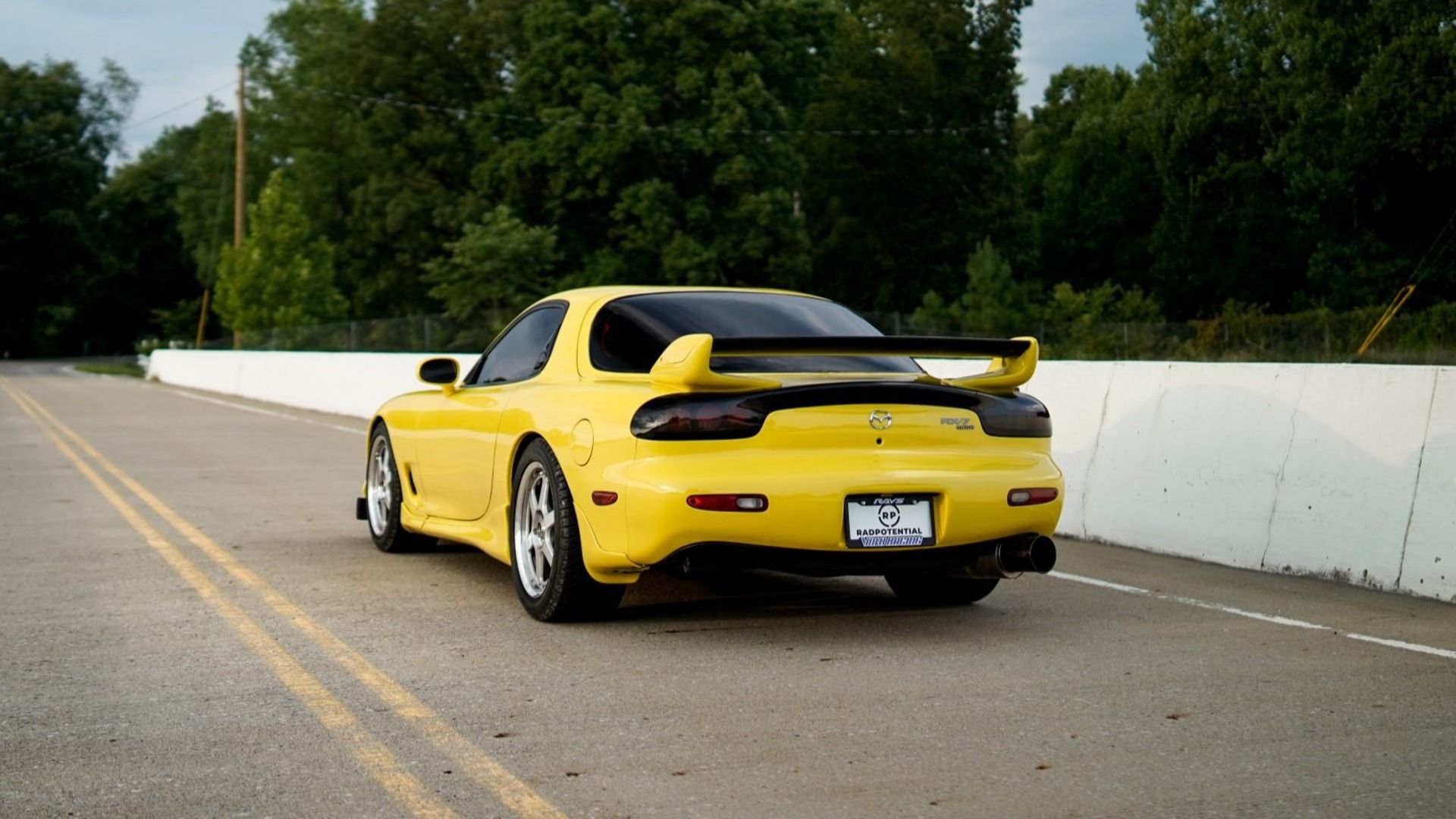 A Modified sun-yellow 1993 Mazda RX-7 R1 5-Speed on the road