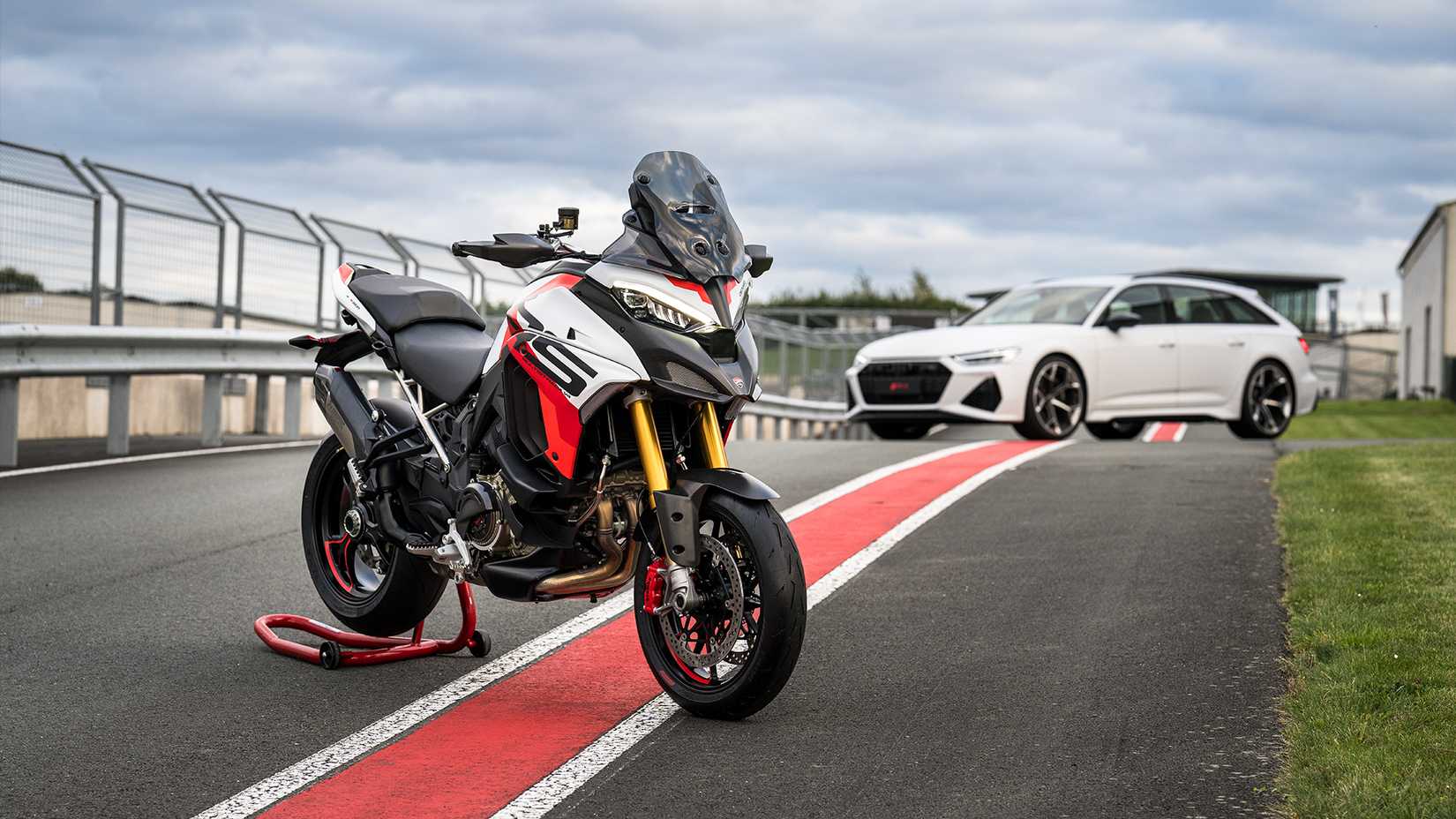 2024 Ducati Multistrada V4 RS and Audi RS6 parked on a track