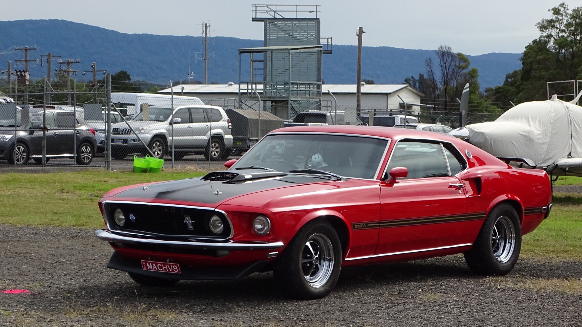 A Red Ford Mach 1 In A Parking Lot