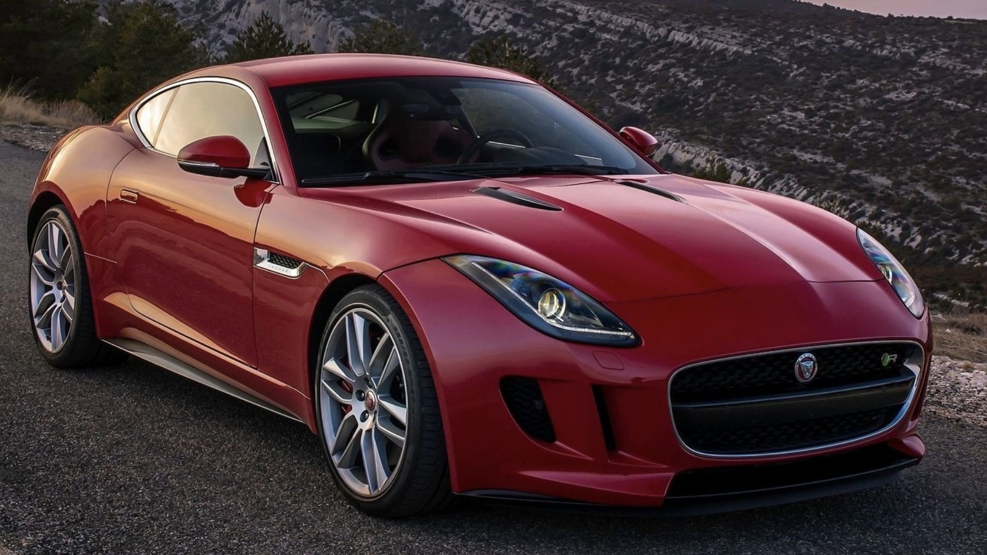 2015 Jaguar F-TYPE Coupe in red posing on mountain road
