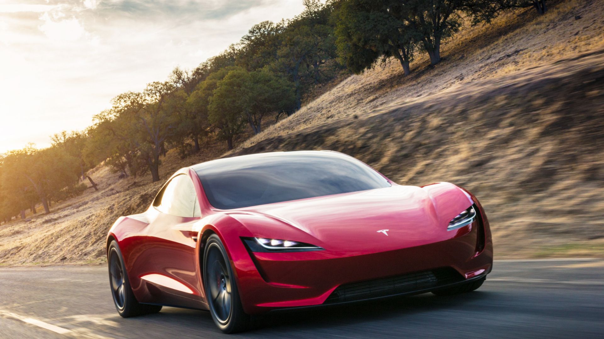 2023 Tesla Roadster in red posing on desert road