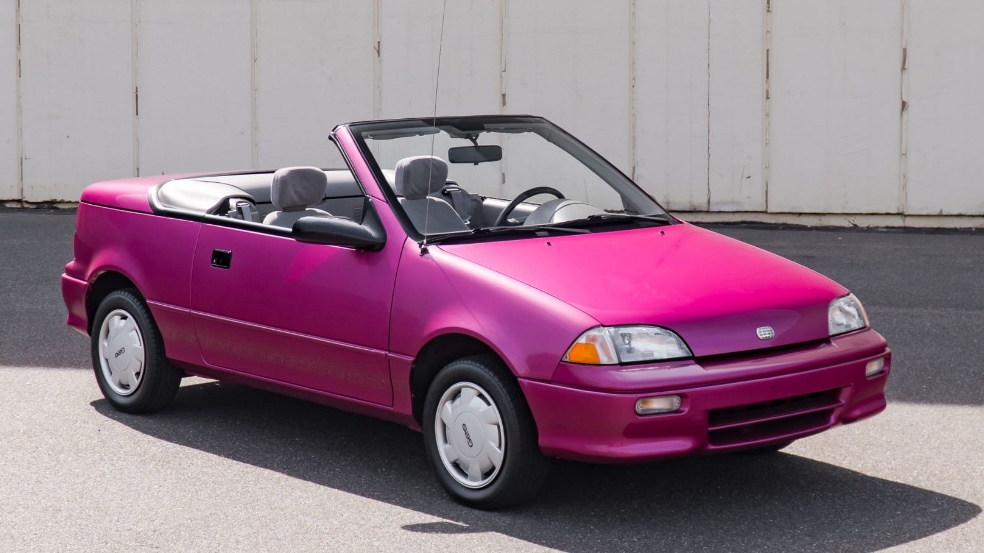 1993 Geo Metro LSI convertible in purple posing in parking lot with roof down