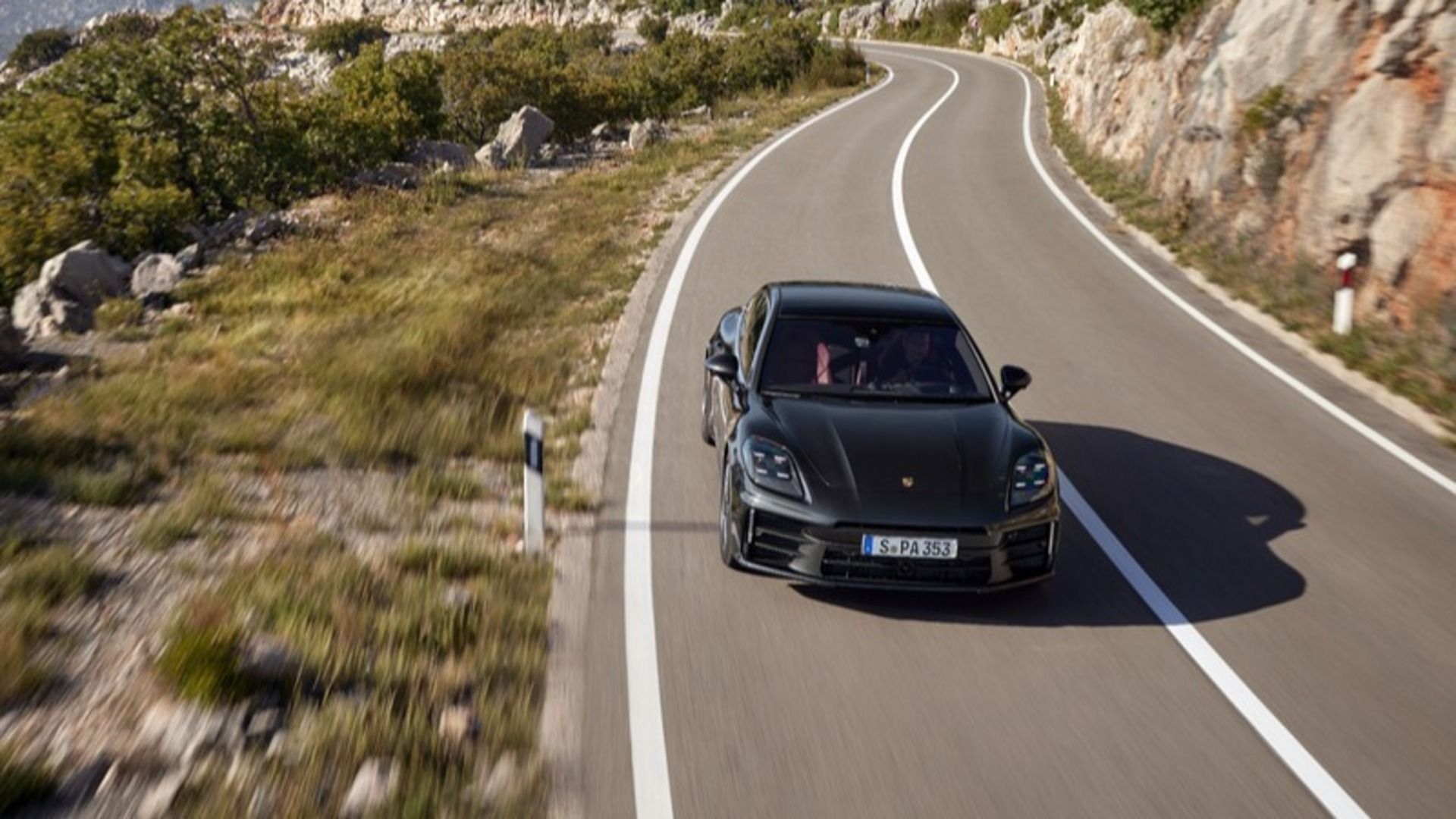 A 2024 Porsche Panamera E-Hybrid crushing a winding back road.