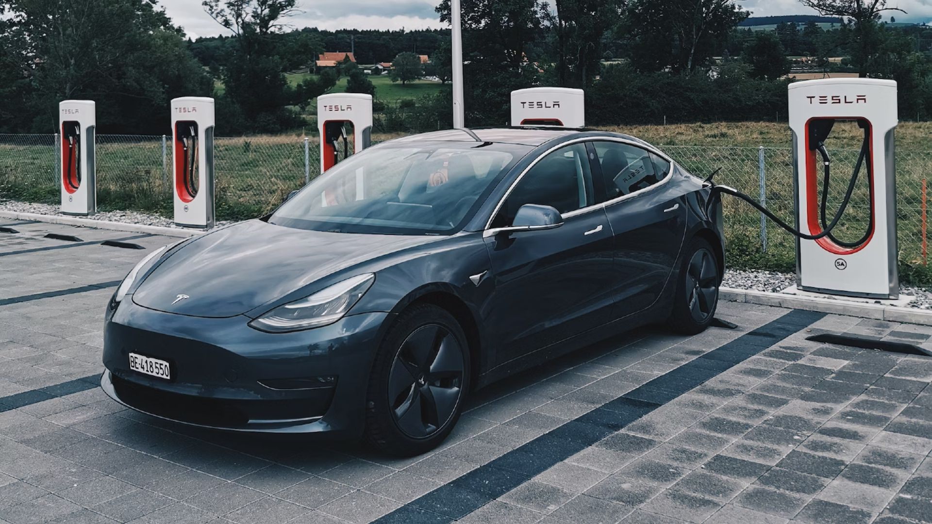 A Tesla Model 3 at a Tesla Supercharger Station
