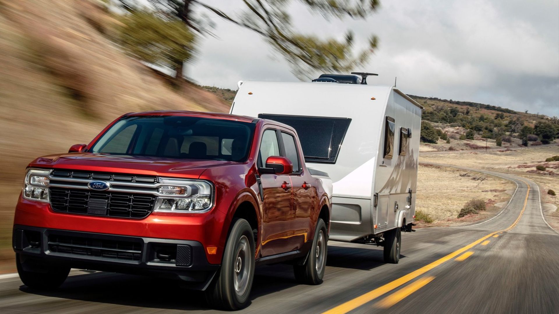 2024 red Ford Maverick towing trailer.