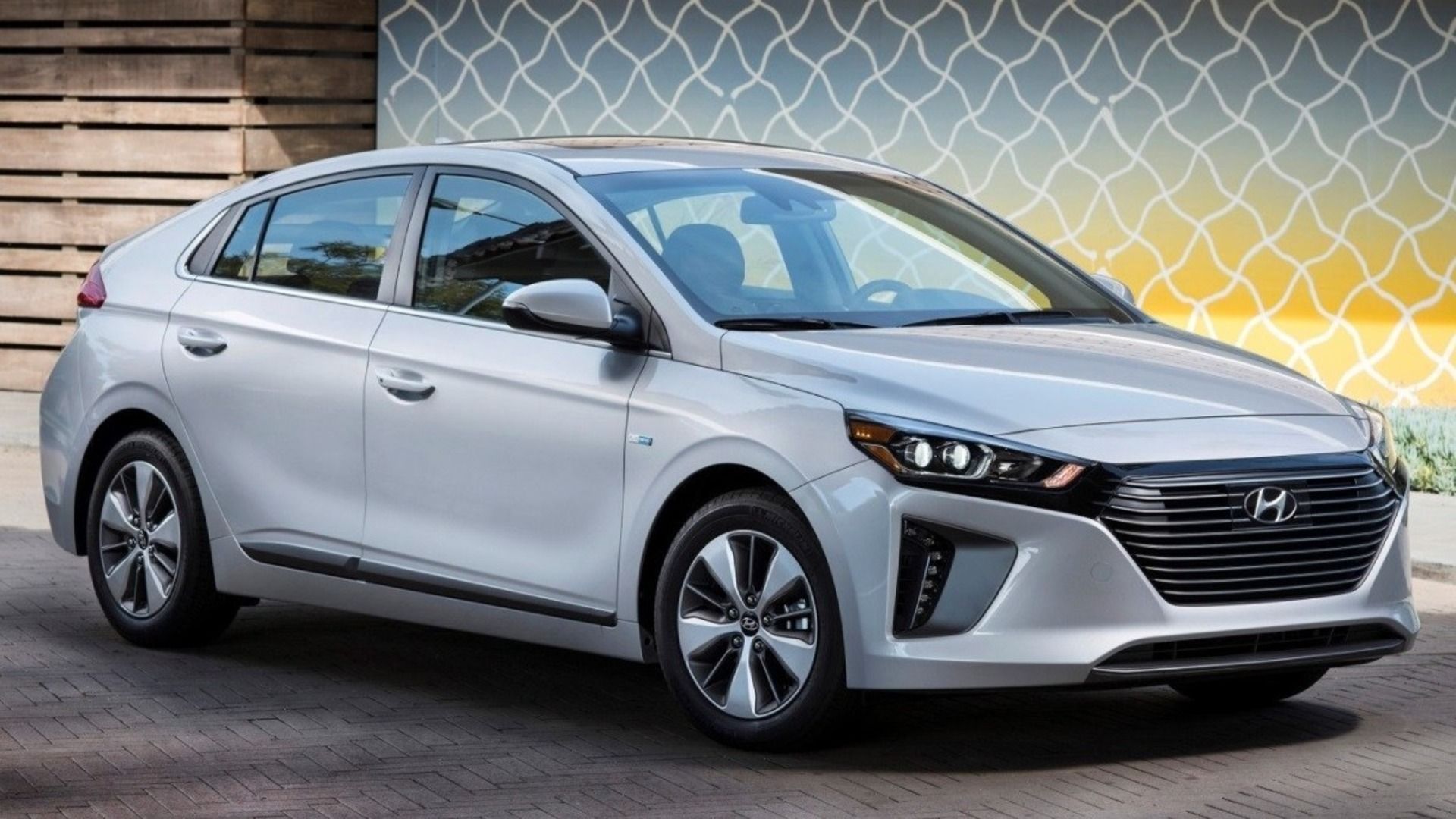 2019 Hyundai Ioniq in silver parked in front of a yellow and white mural.
