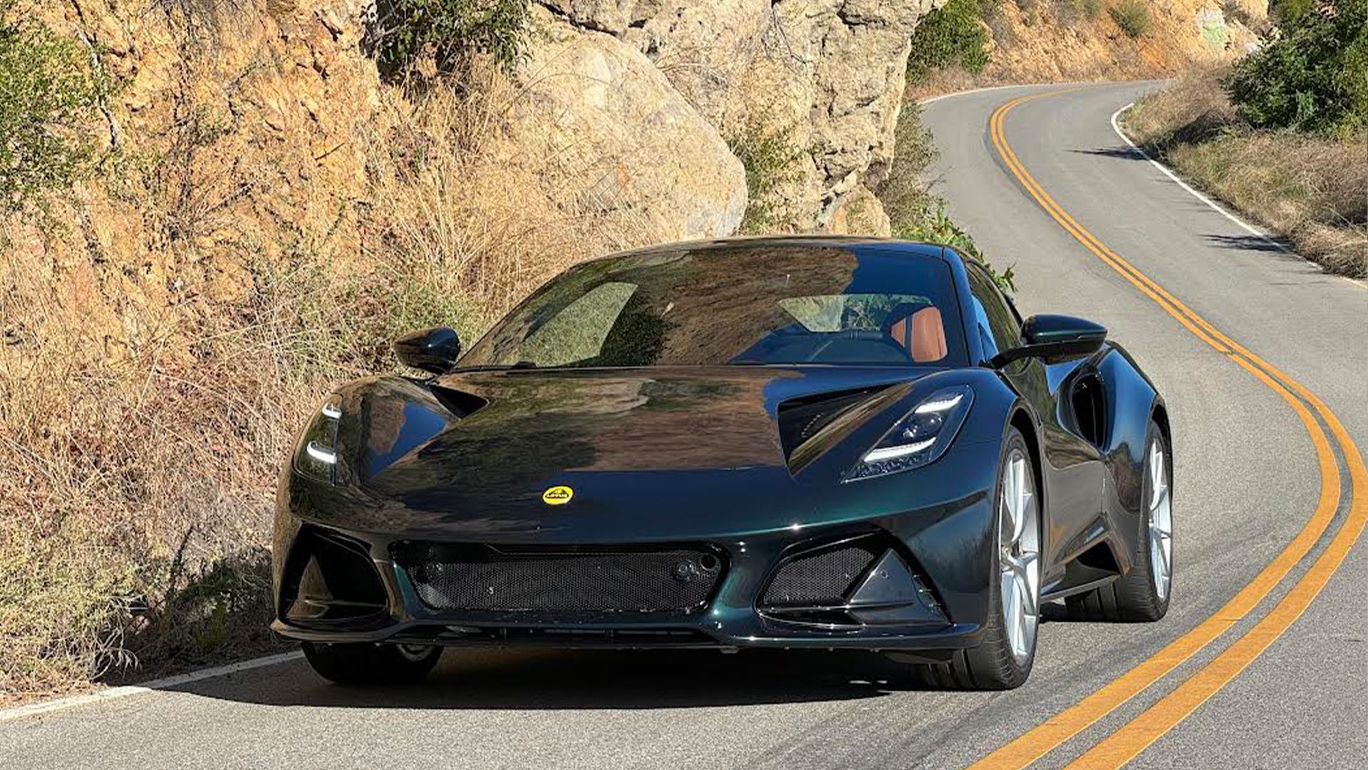 Lotus Emira verde 2024 dirigindo em estradas sinuosas 