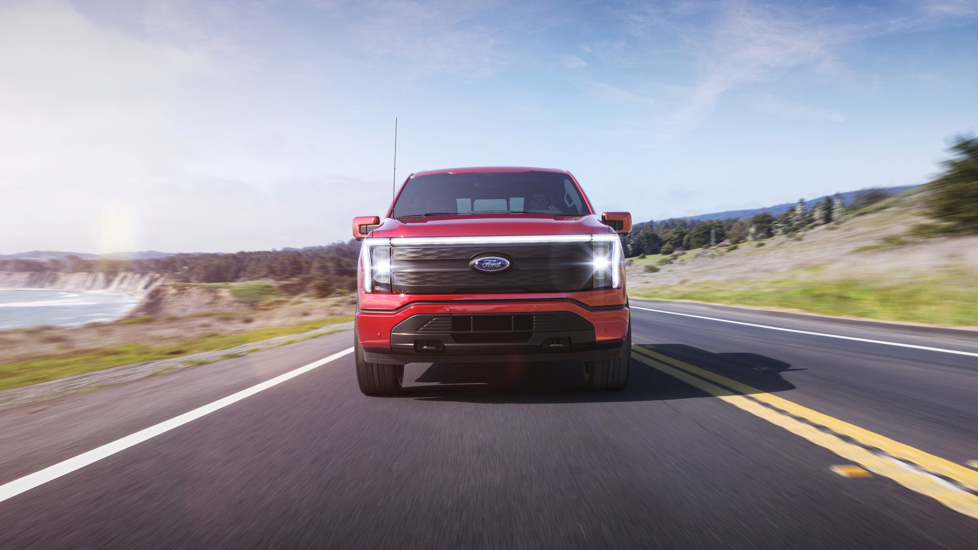 Red F150 Lightning head-on image with lights on