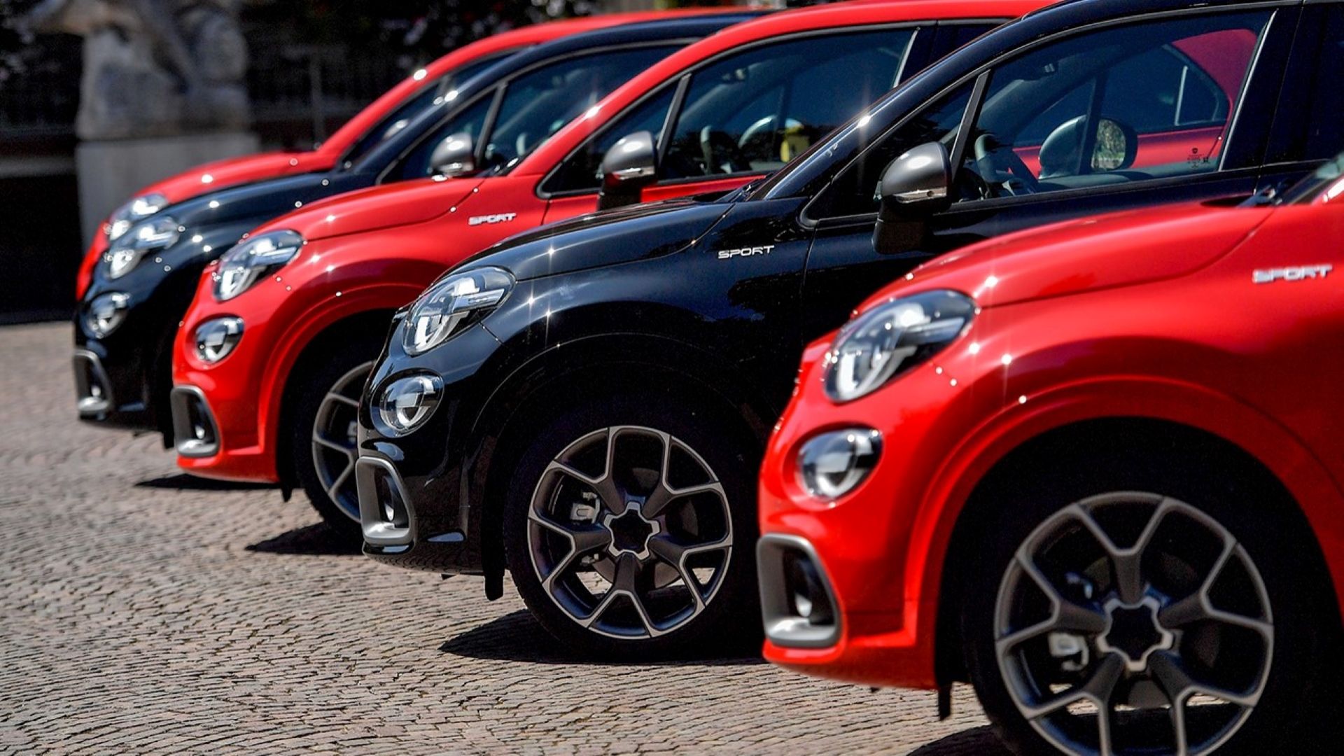 A lineup of a number of Fiat 500Xs in red and black