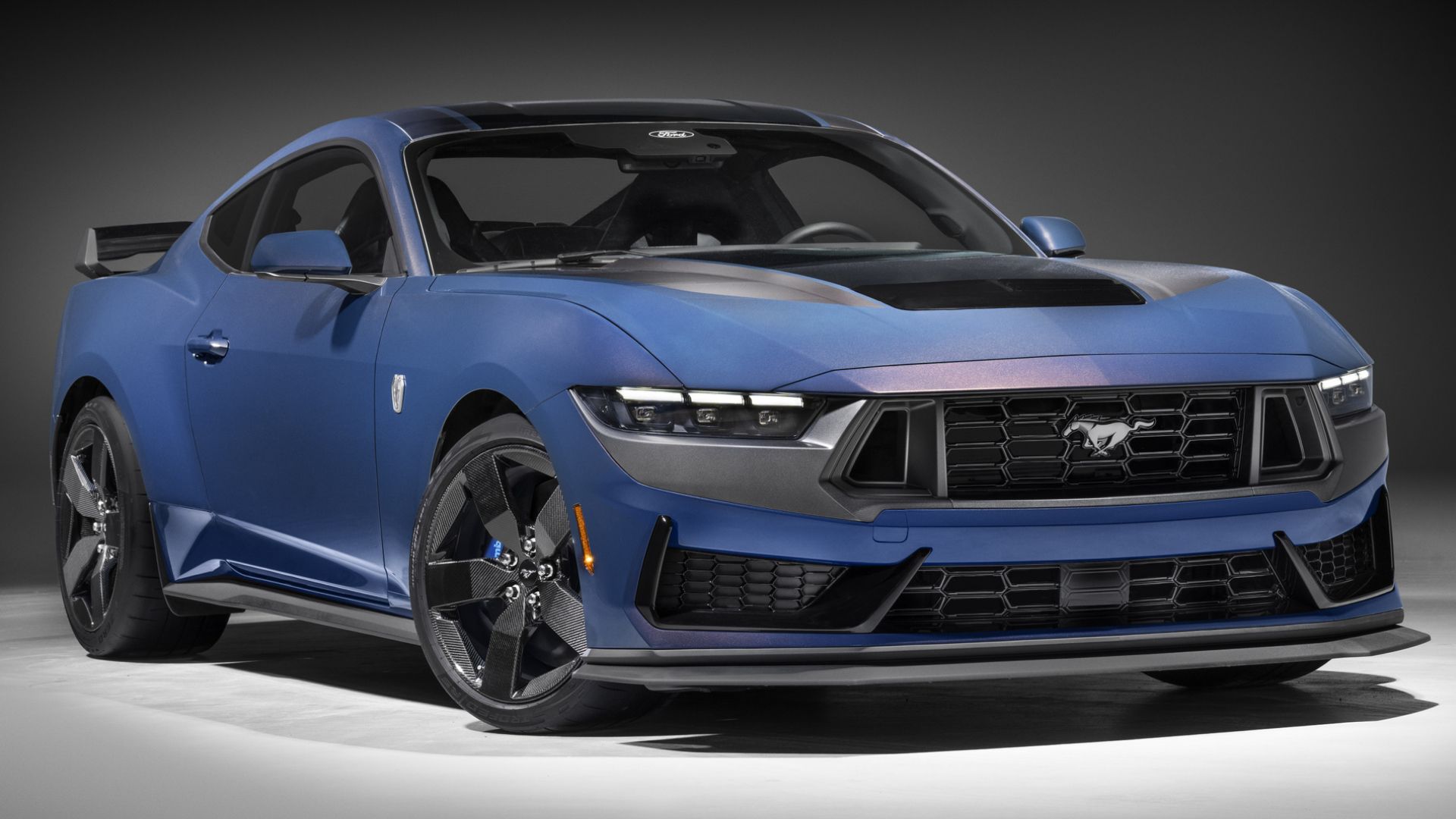 2024 Ford Mustang Dark Horse in blue featuring carbon-fibre wheels posing in studio
