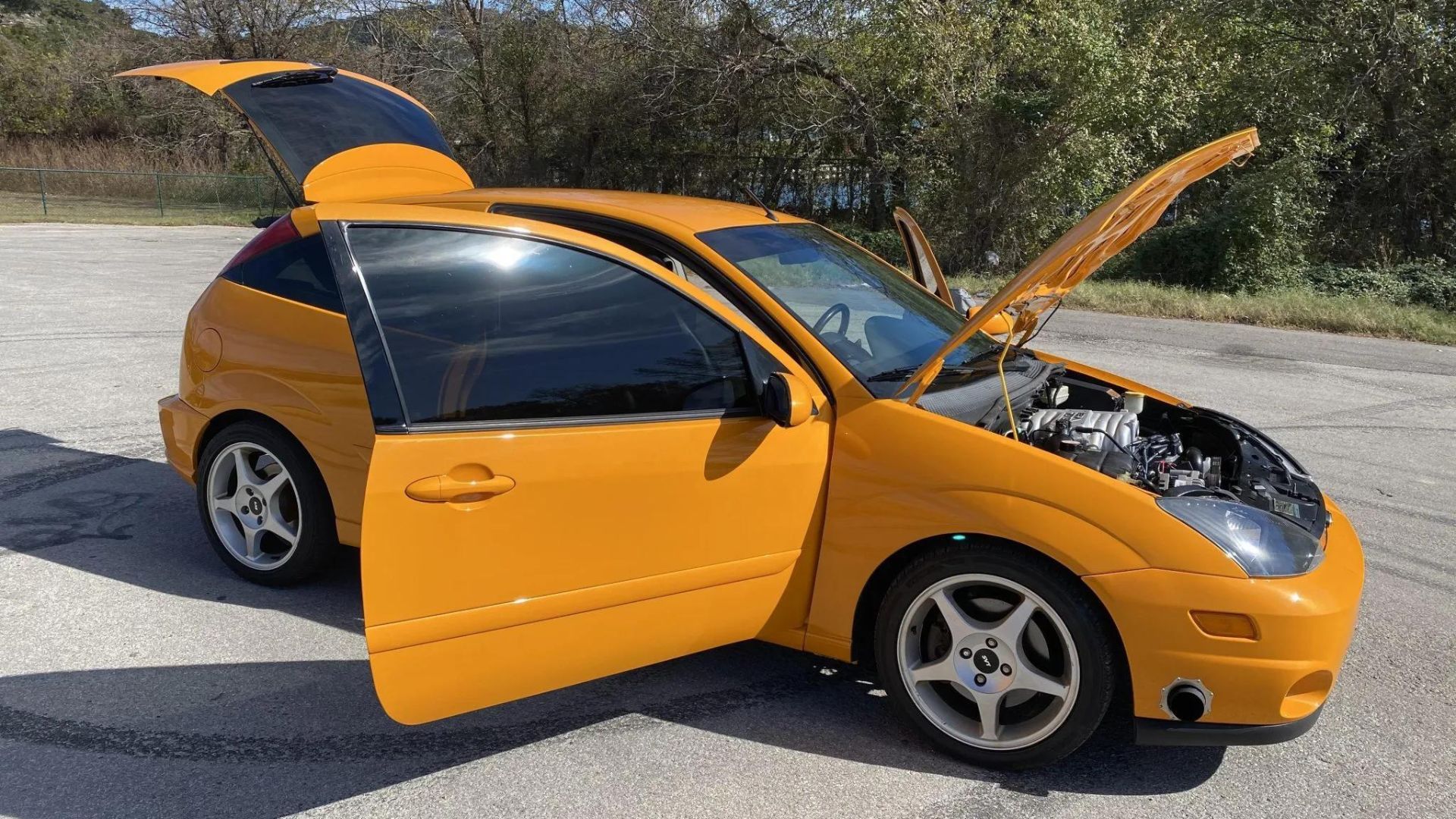 Modified 2003 Ford Focus parked with all doors open