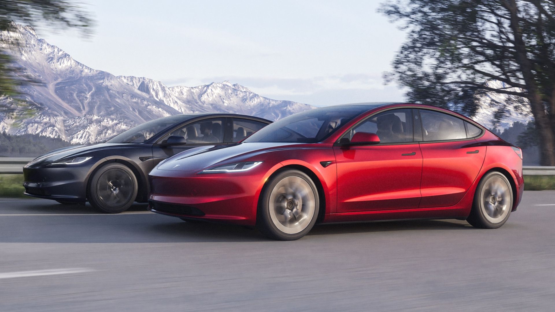 Gray and red Tesla Model 3 front-quarter driving