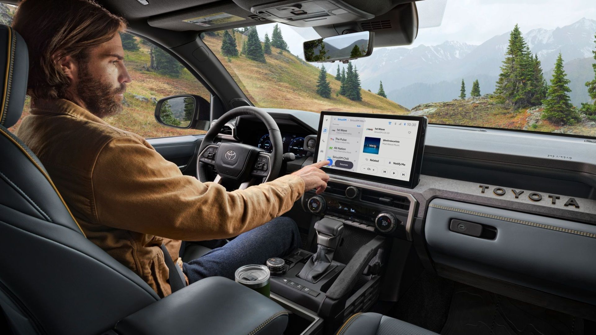 Toyota Tacoma Trailhunter front interior shot with the driver operating the big touchscreen display.