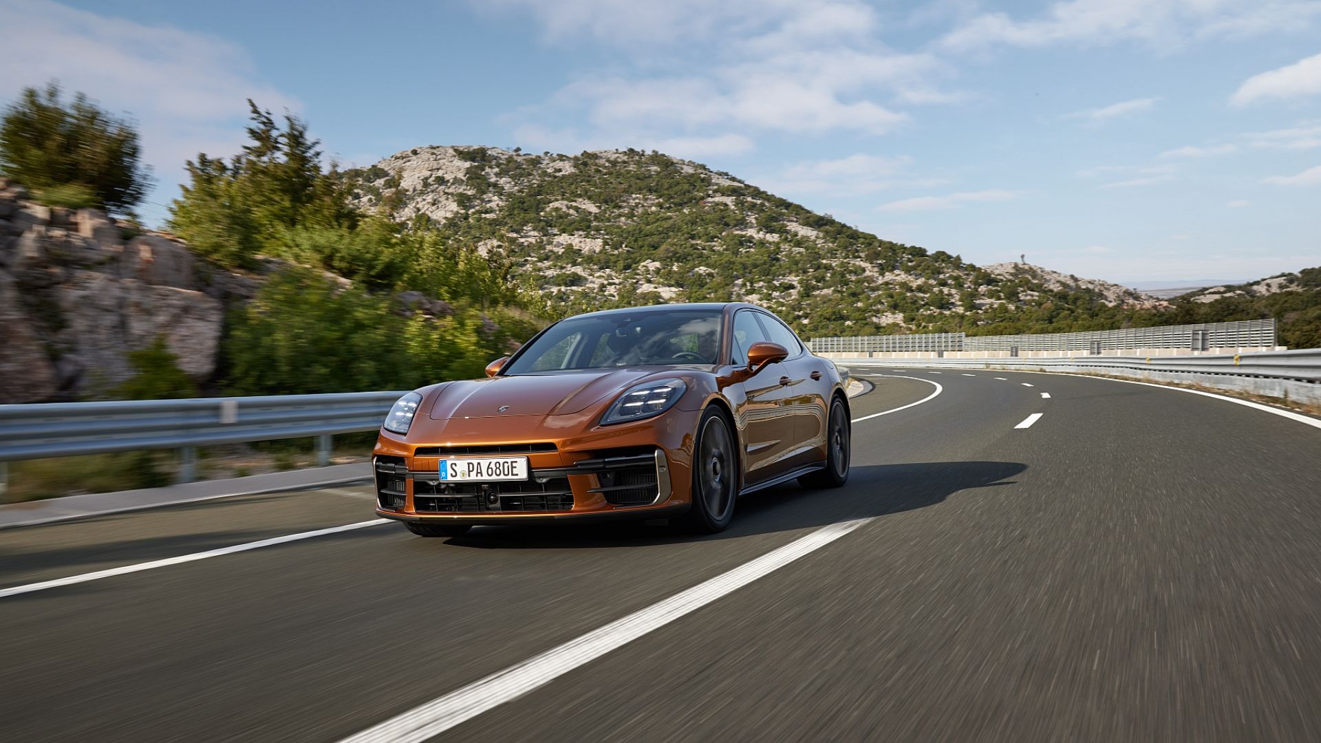 2024 Porsche Panamera driving on a mountain road front angle view