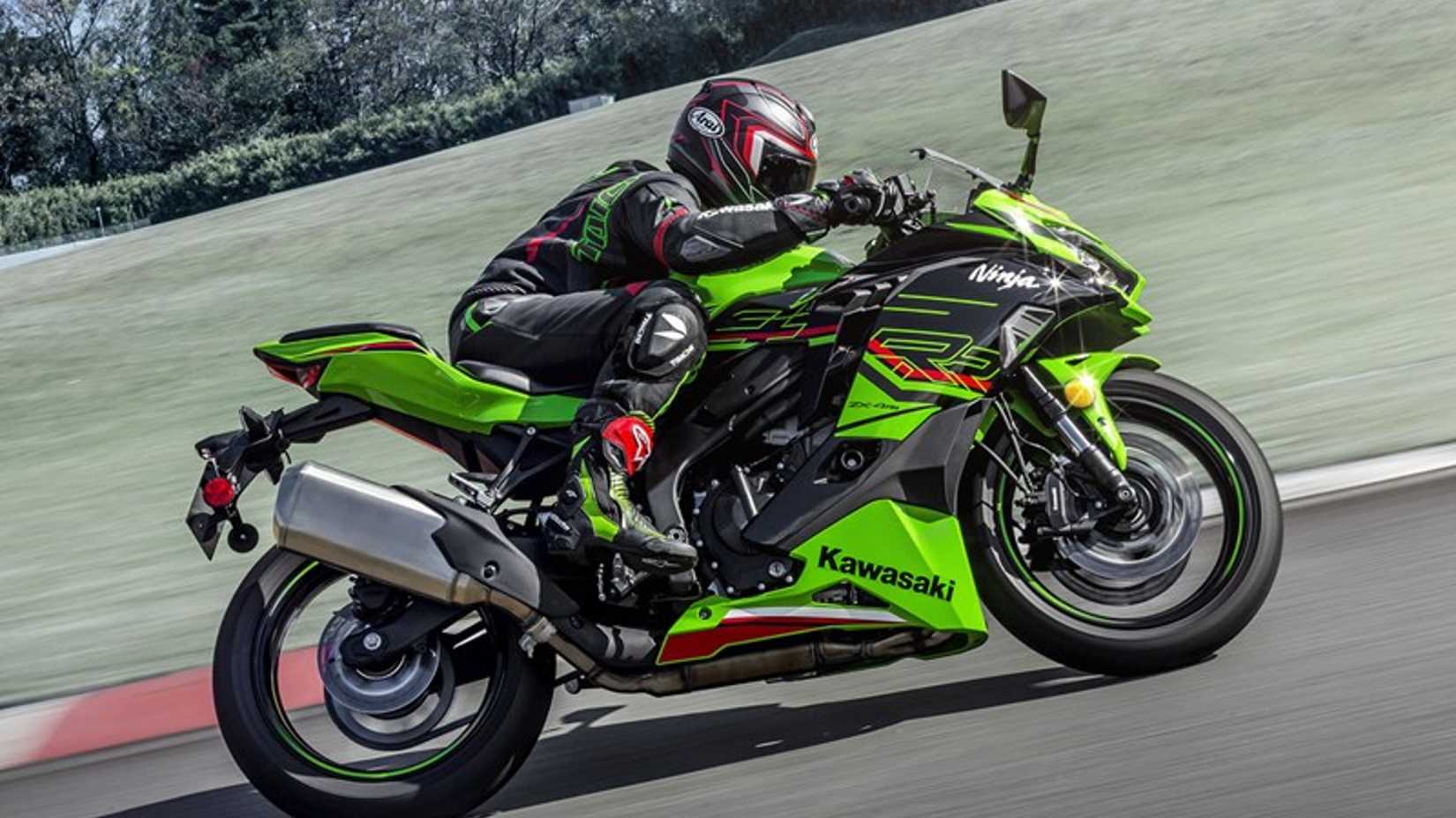 Side profile action shot of Kawasaki Ninja ZX-4R exiting a corner on a racetrack. 