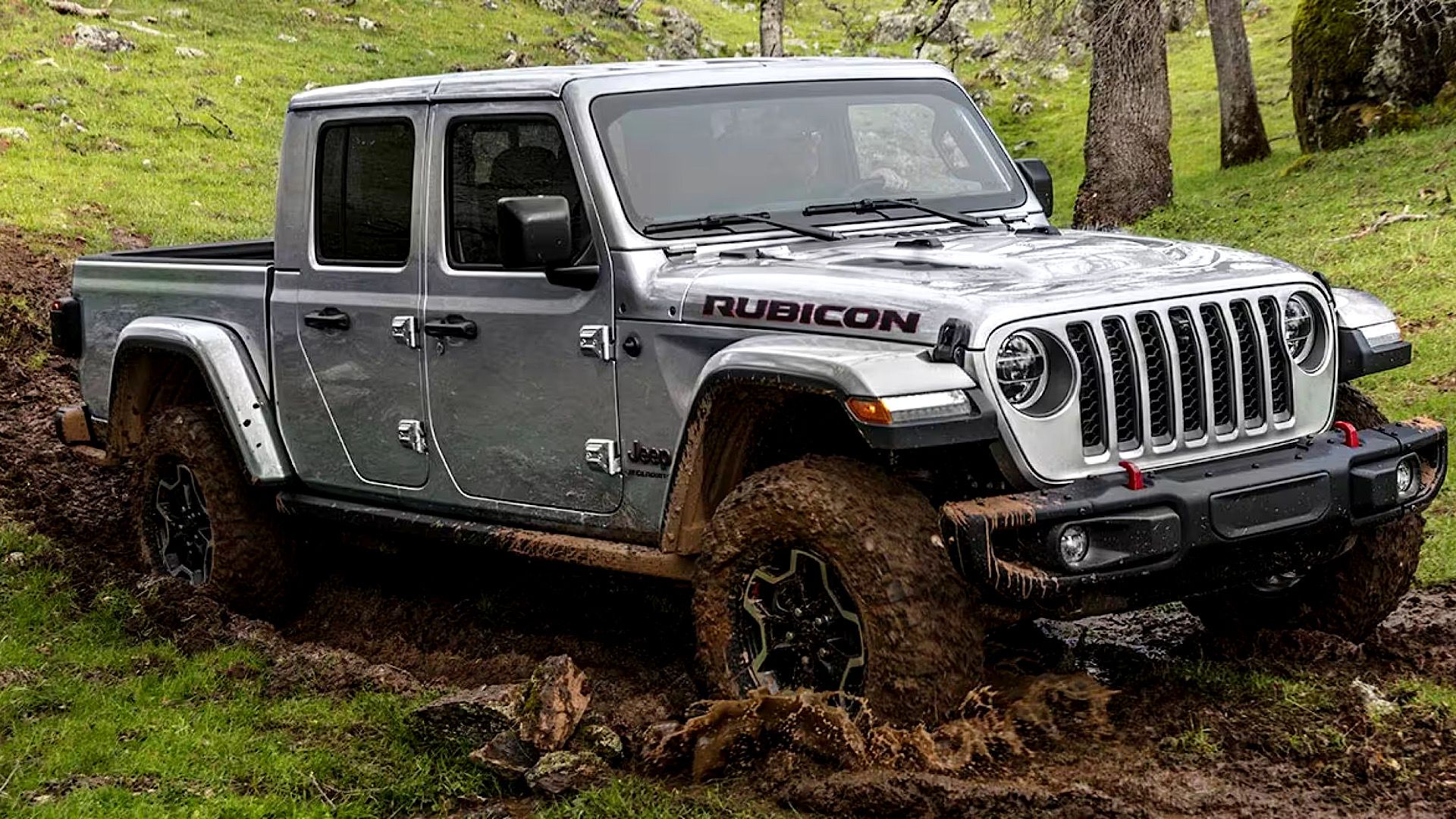 2023 Jeep Gladiator in polished silver Navigating through muddy off-road terrain