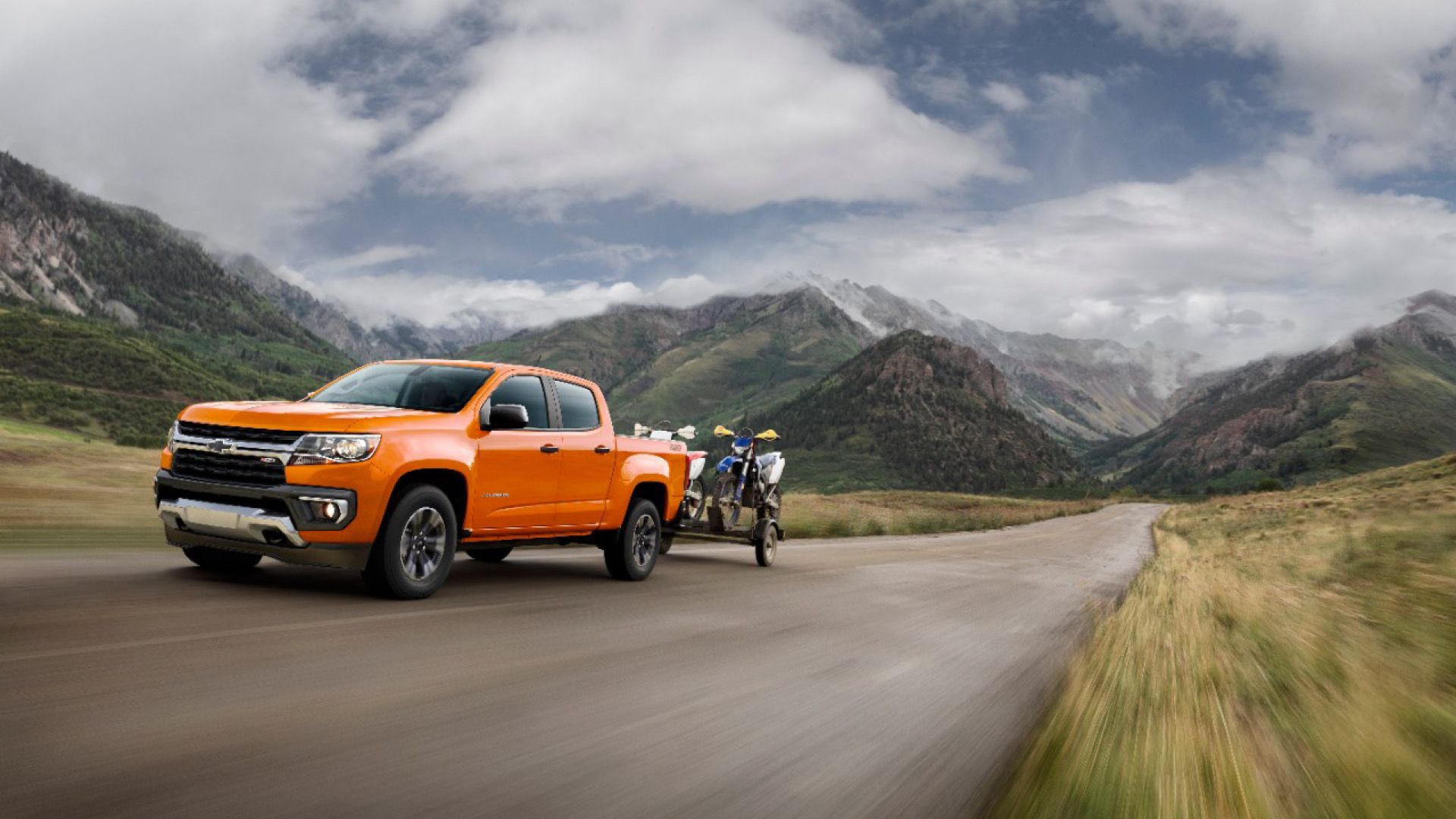 2021 Chevrolet Colorado In orange Posing on mountain road towing trailer