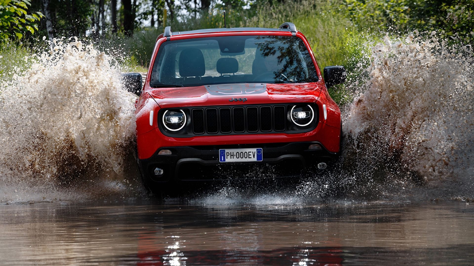 2024 Jeep Renegade Hybrid Plug-In in red Driving through deep and muddy puddle