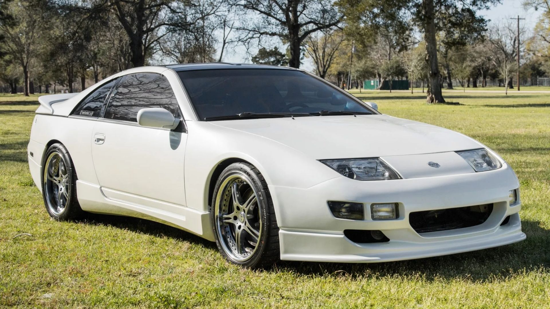 A white 1994 Nissan 300ZX front 3/4 exterior shot while parked on a grass field