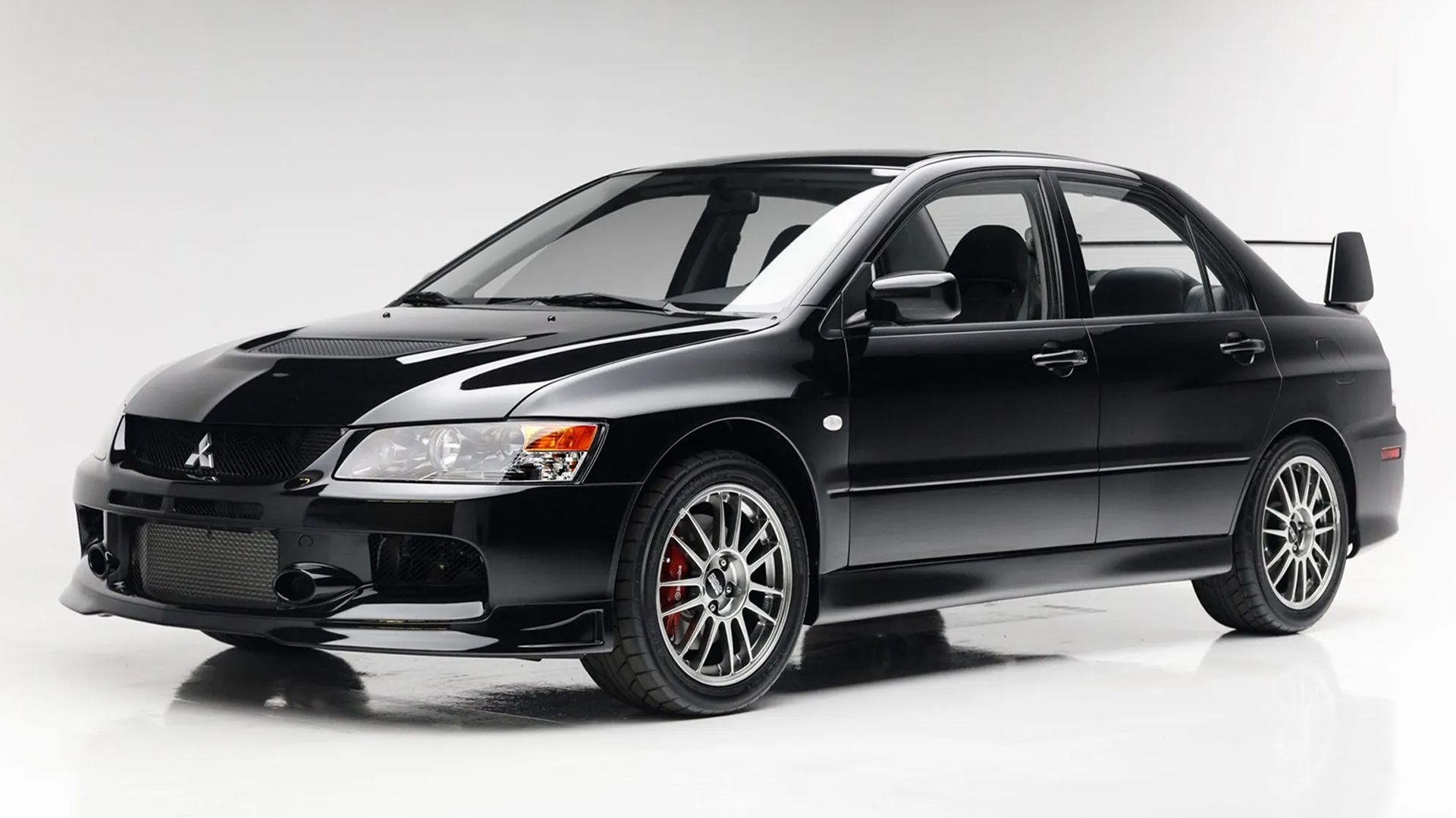 A Black 2006 Mitsubishi Lancer Evolution IX front 3/4 studio shot