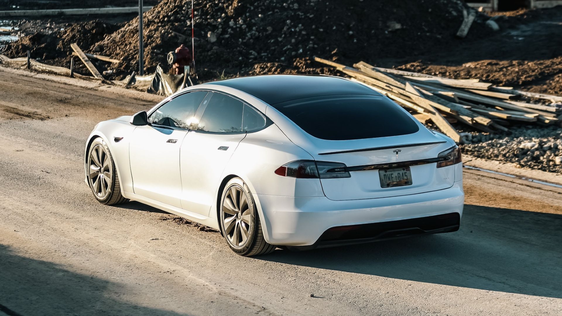 Rear three-quarters shot of a parked 2021 White Tesla Model S Plaid