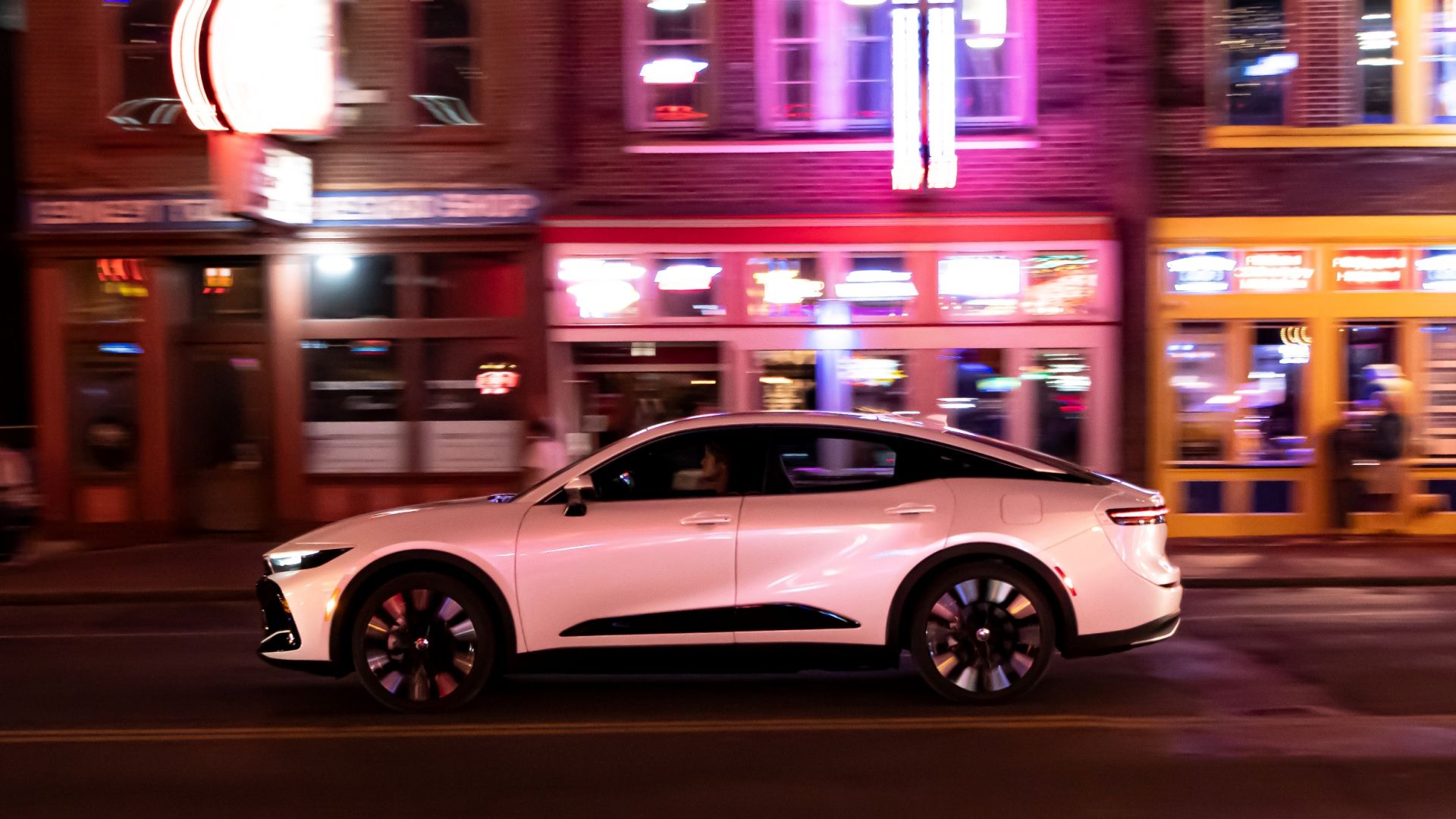 2024 Crown Platinum in OxygenWhite side left exterior shot driving on the street at night.