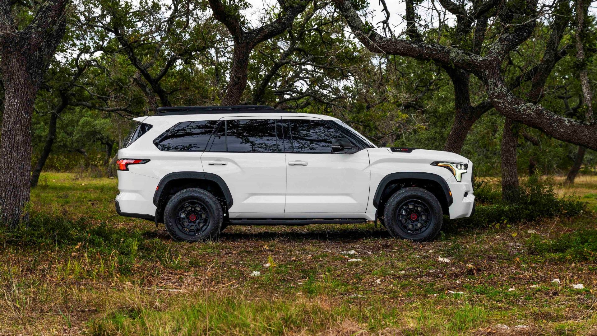 2024 Toyota Sequoia TRD Pro White filmado lateralmente em uma floresta