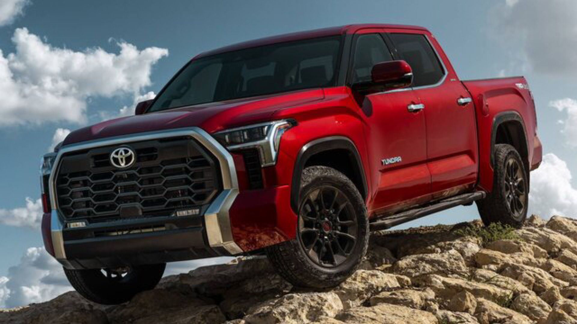 2024 Toyota Tundra SR in red poses on rocky terrain