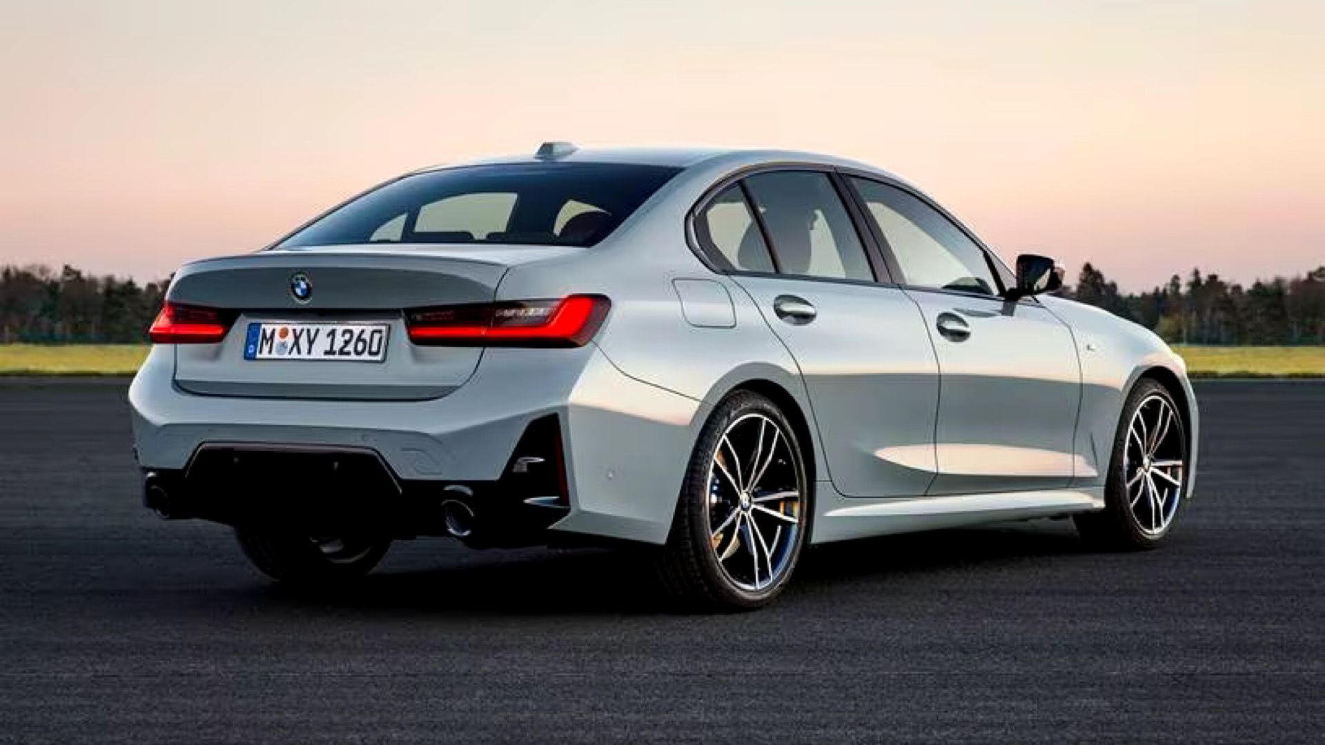 2024 BMW 330i Sedan in silver Posing on tarmac with countryside in background