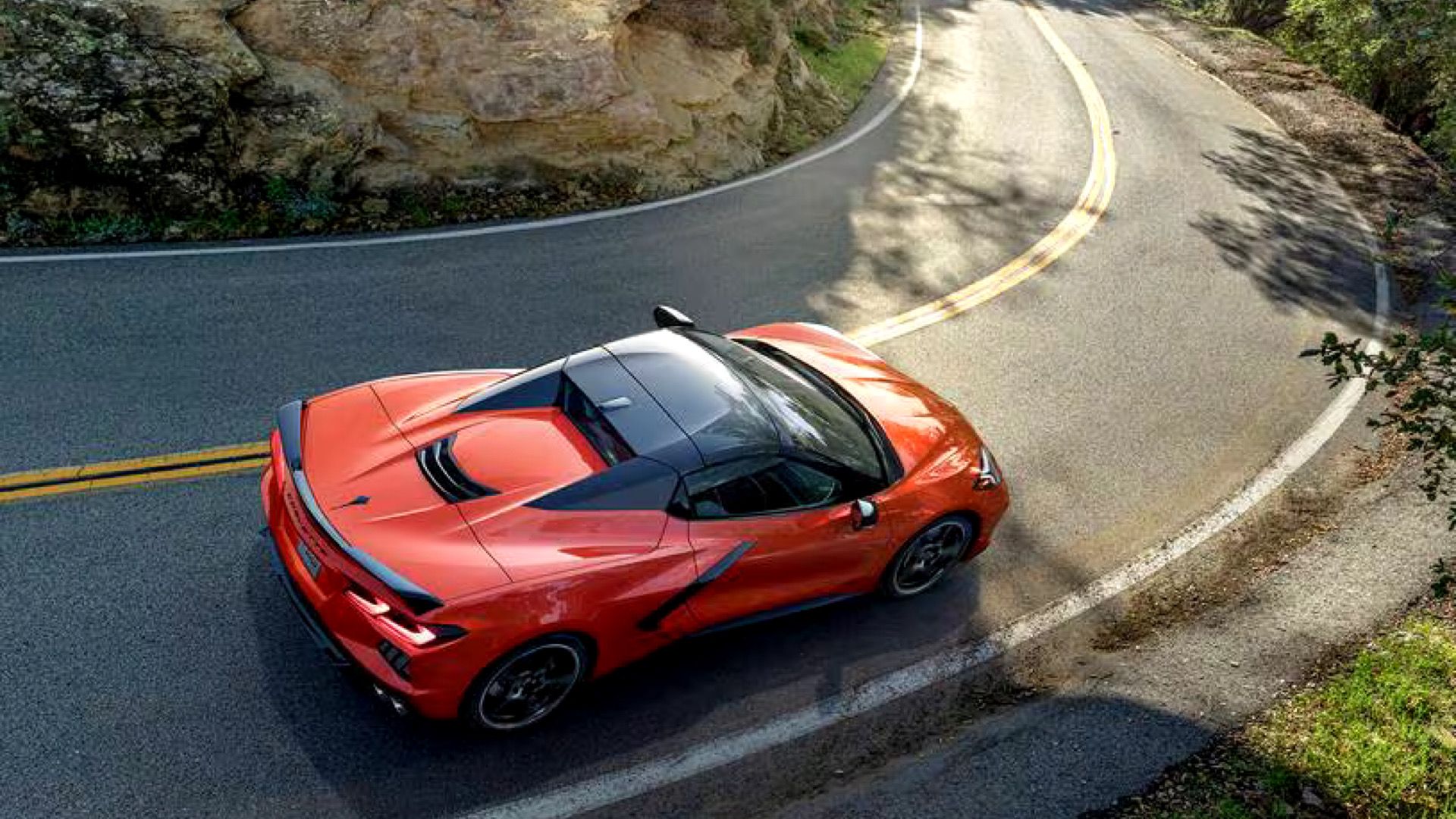 2023 Chevrolet Corvette Stingray C8 in orange Posing on winding country road