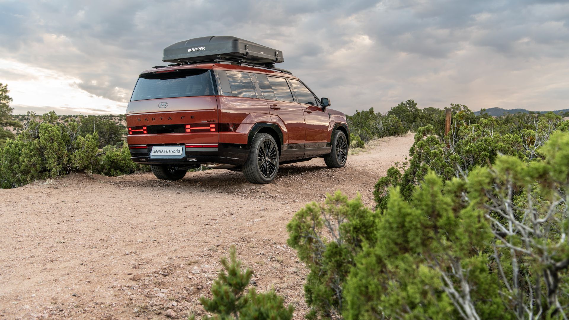 2024 Hyundai Santa FE Hybrid in a desert terrain driving in the opposite direction.