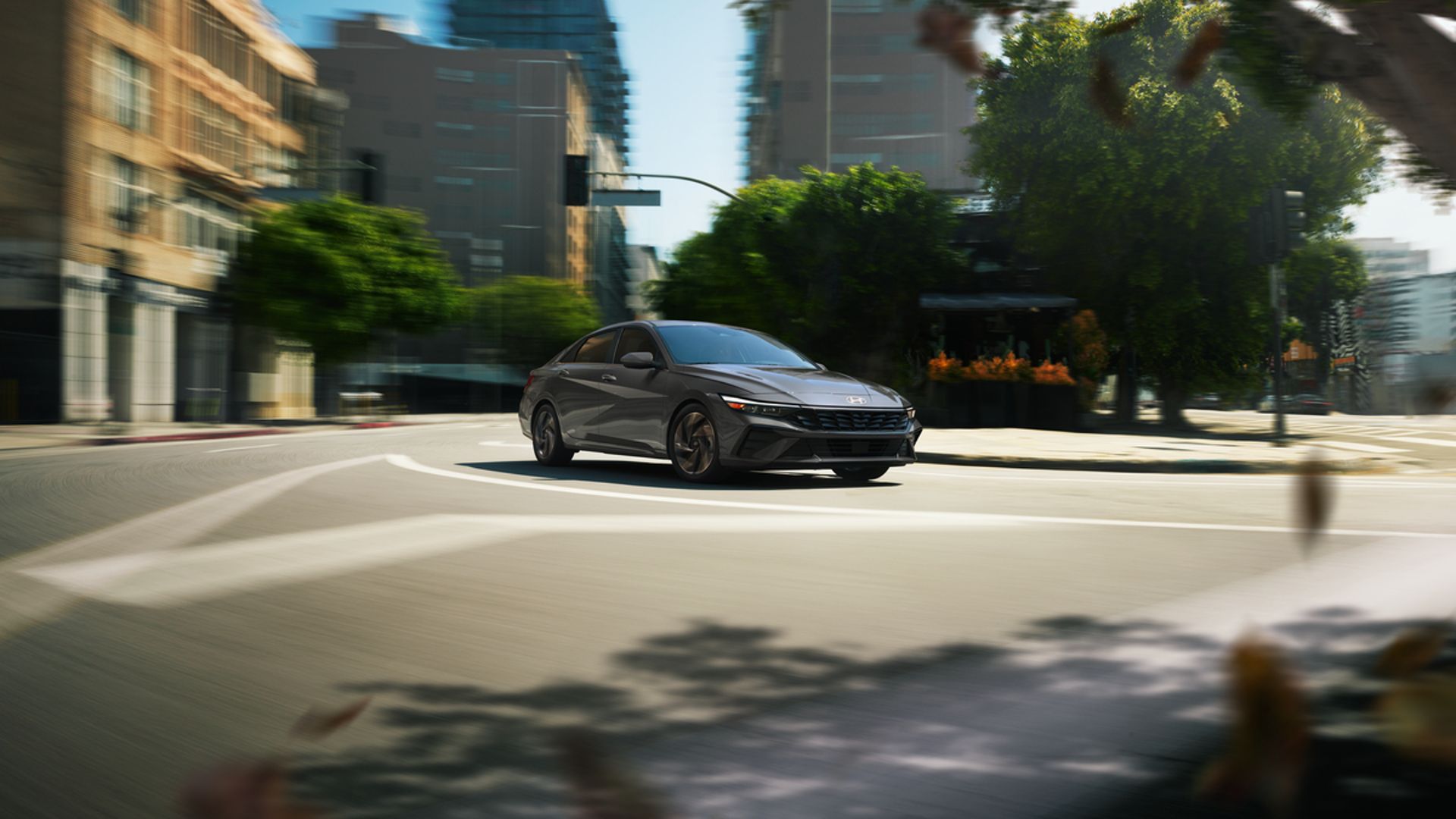 A 2024 Hyundai Elantra Hybrid driving on the road.