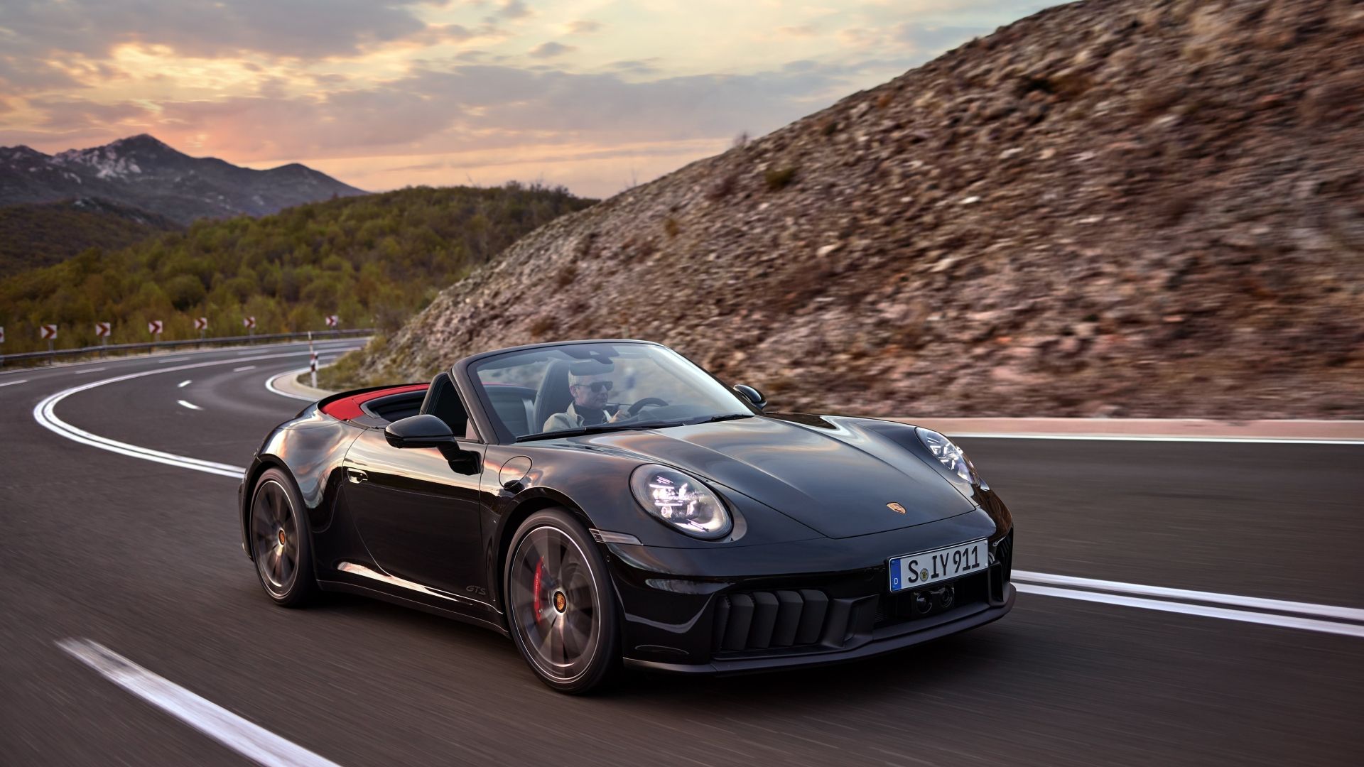 Foto frontal de três quartos de um Porsche 911 Cabriolet preto 2025 