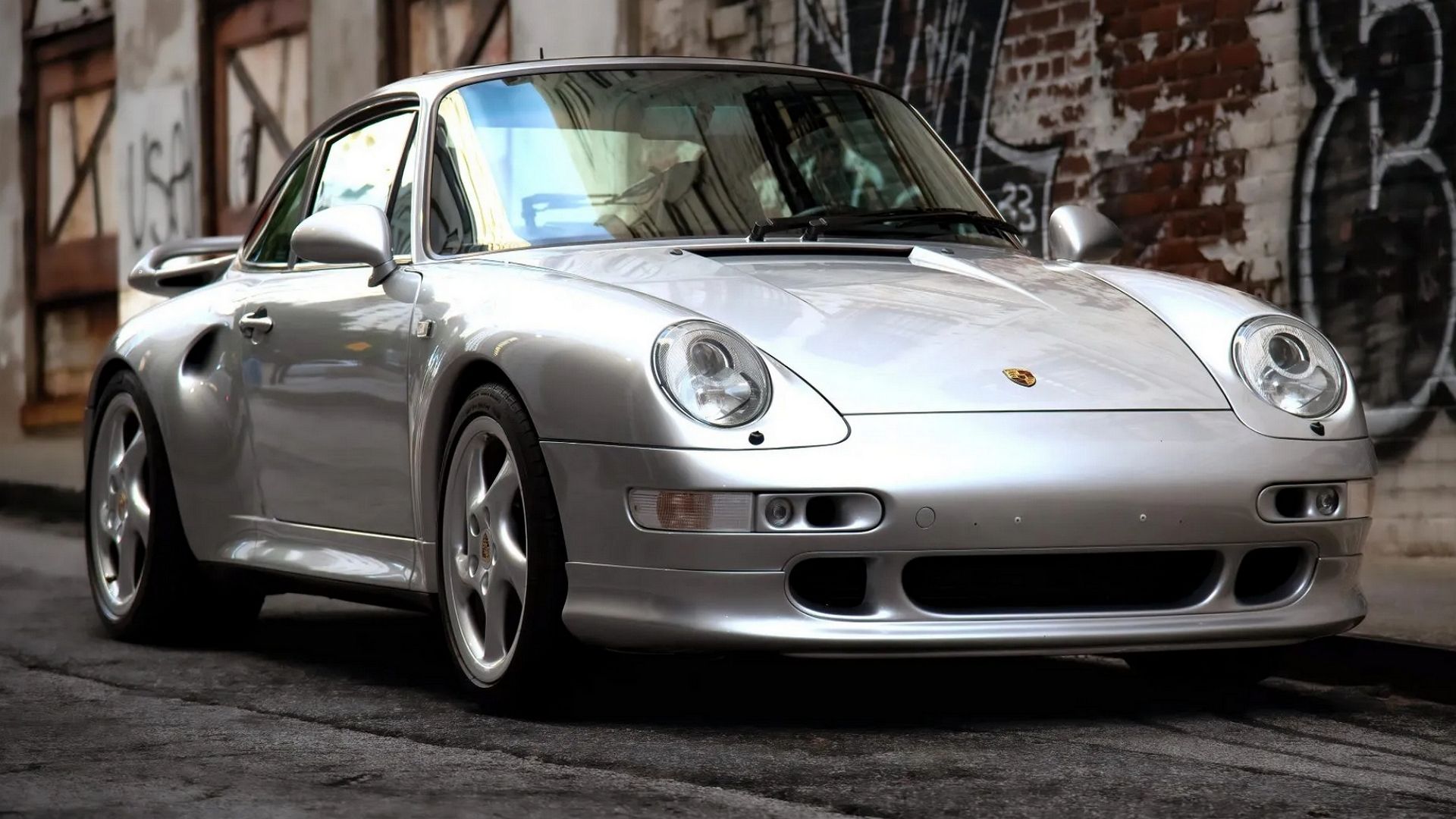 A front 3/4 shot of a Silver 1997 Porsche 911 Carrera S Coupe.