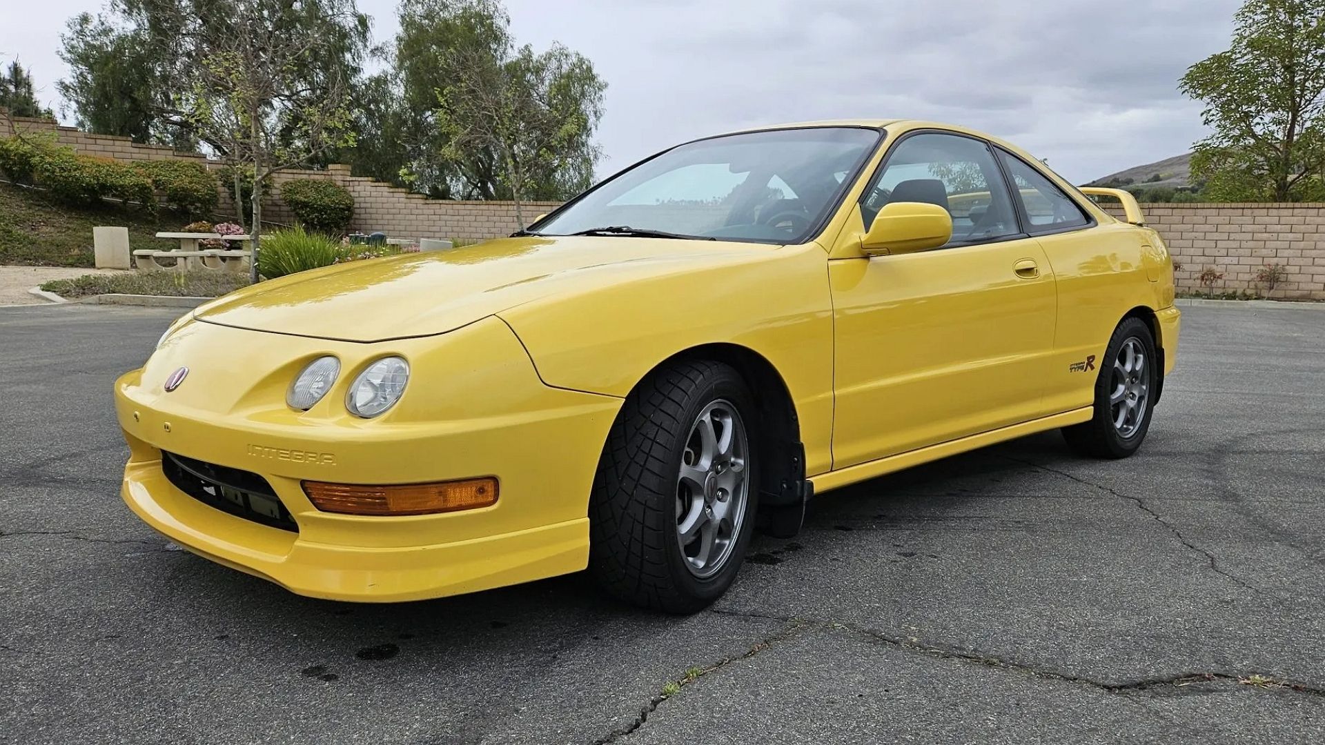 Uma foto frontal 3/4 de um Acura Integra Type R amarelo 2001.