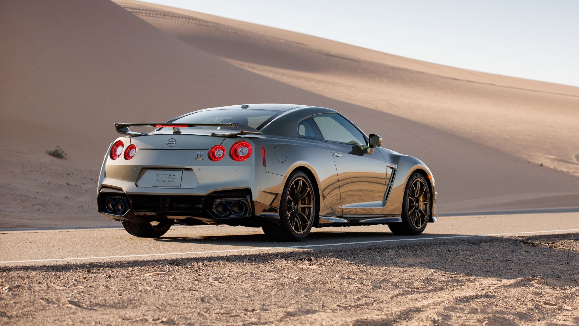 2024 Nissan GT-R T-spec traseira 3/4 externa tirada em uma estrada deserta