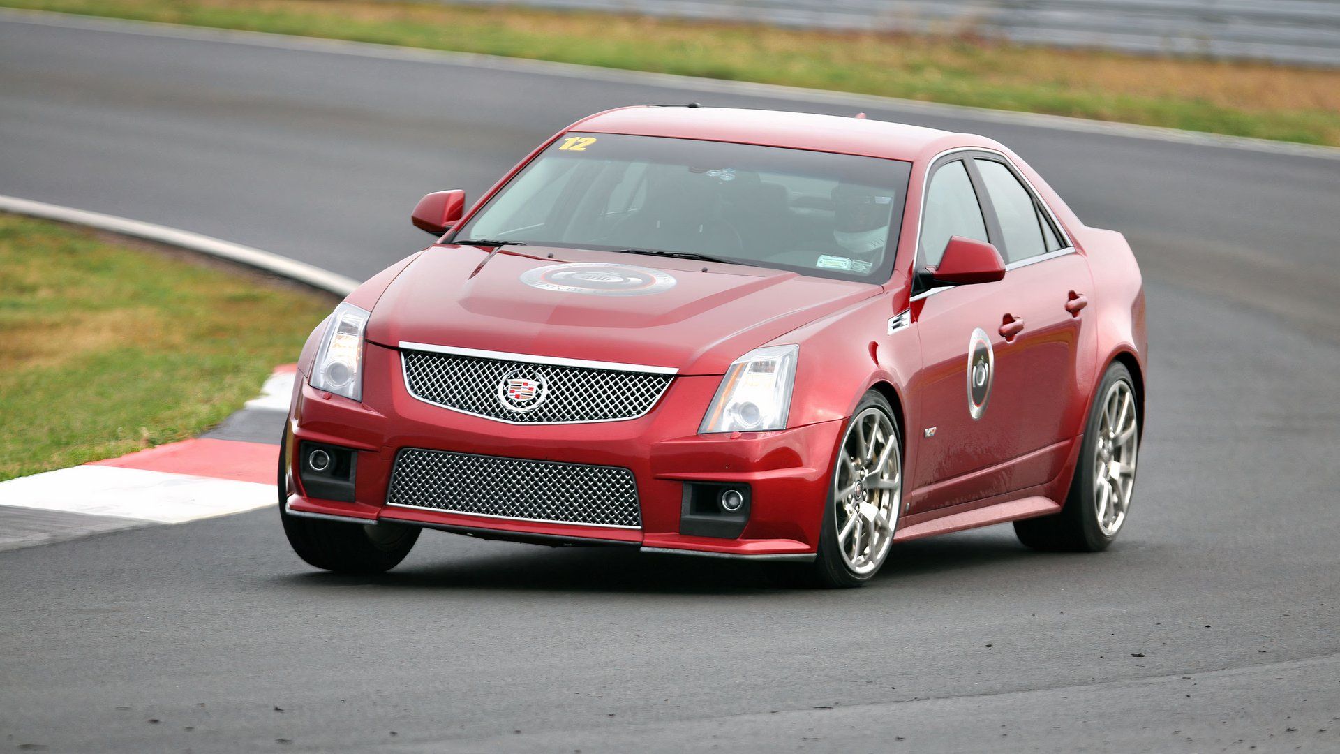 Sedan Cadillac CTS-V vermelho 2012 dirigindo na pista