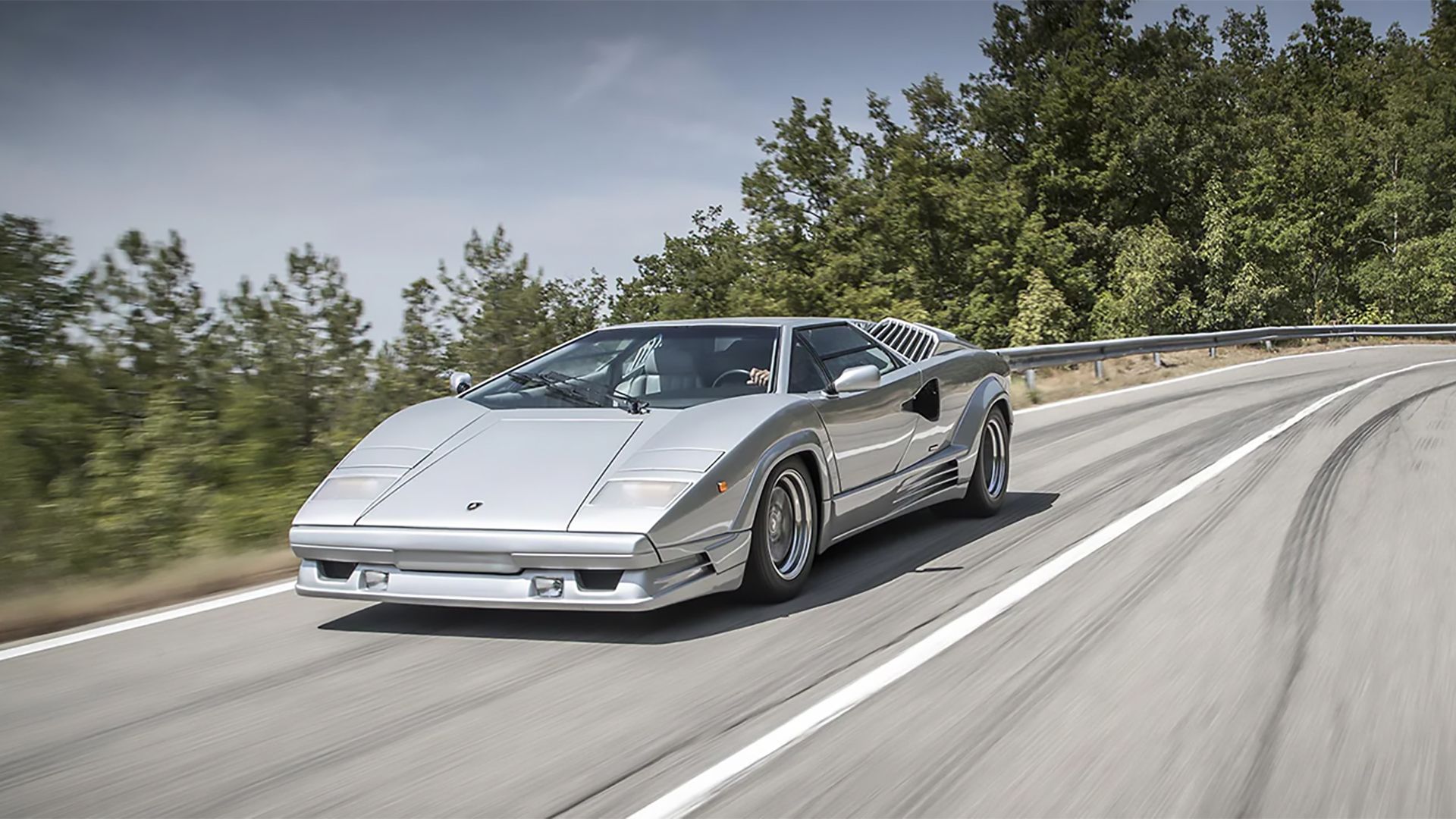 Um Lamborghini Countach LP400S prateado dirigindo