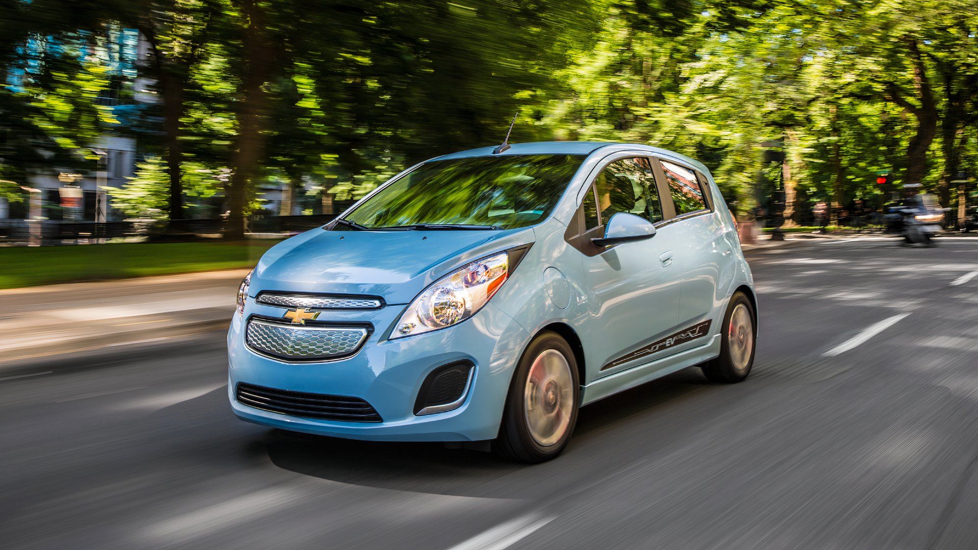 Front three-quarters action shot of a blue 2016 Chevrolet Spark EV