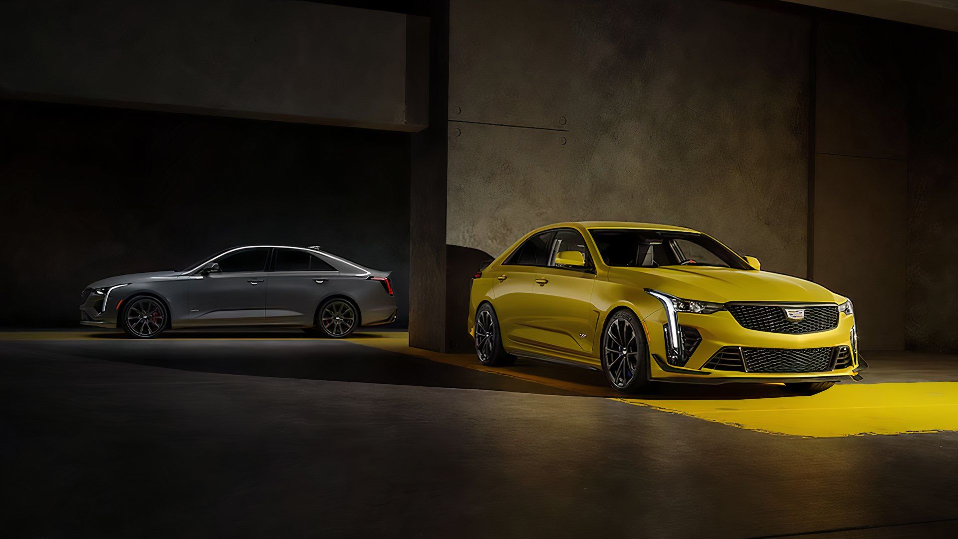 Um Cadillac CT4-V Blackwing 2024 amarelo estacionado na frente de um CT5-V cinza