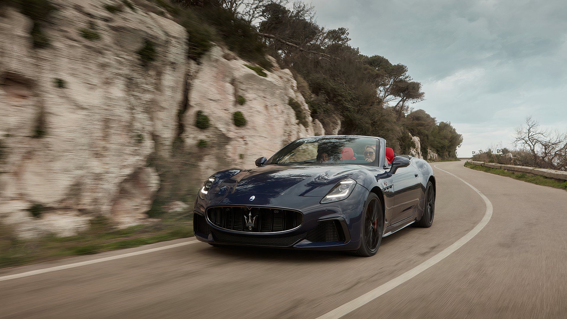 A Dark Blue 2024 Maserati GranCabrio Trofeo Driving