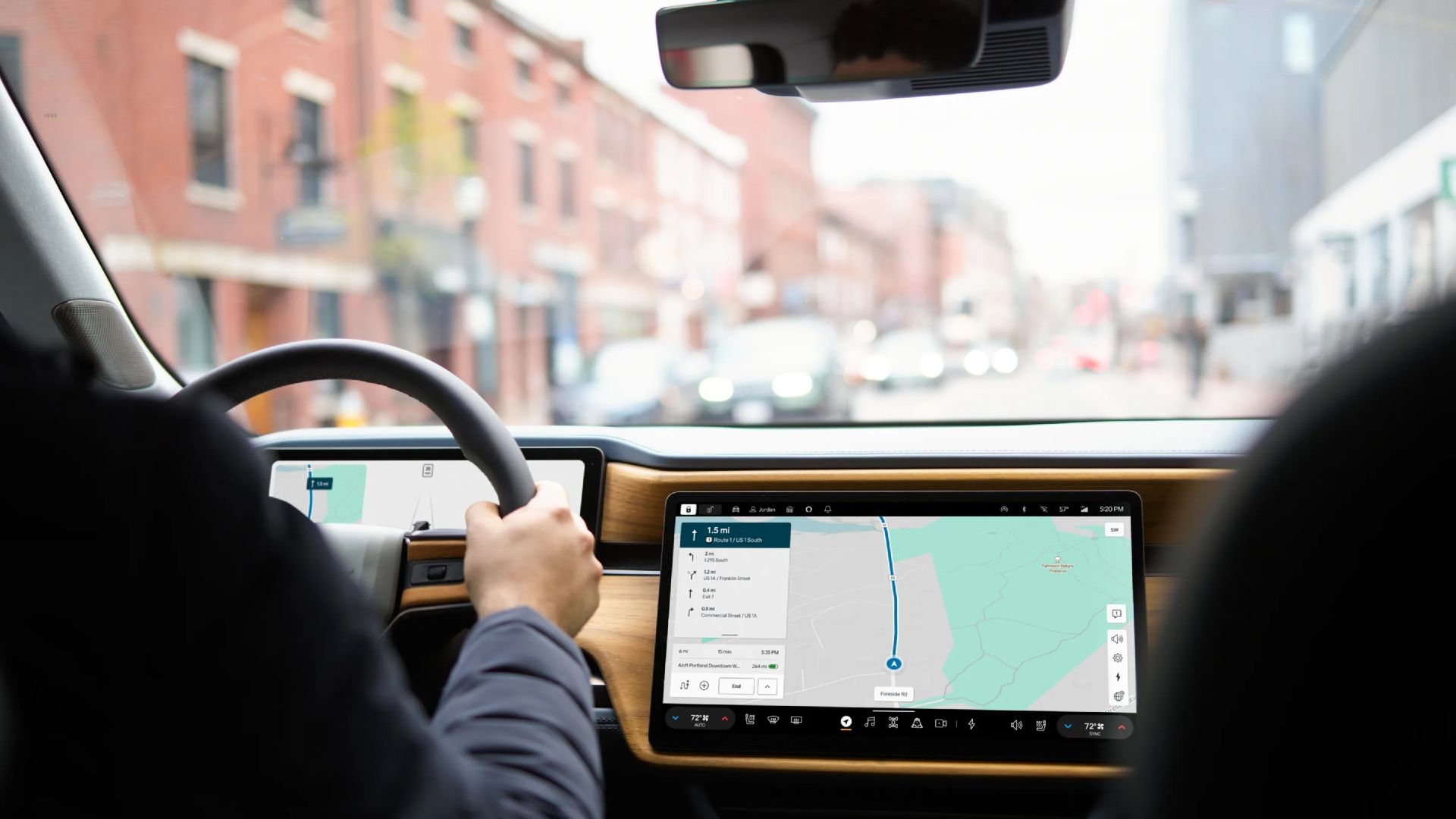 Interior shot of the 2025 Rivian R1S showcasing the dash, steering wheel, and touchscreen system.