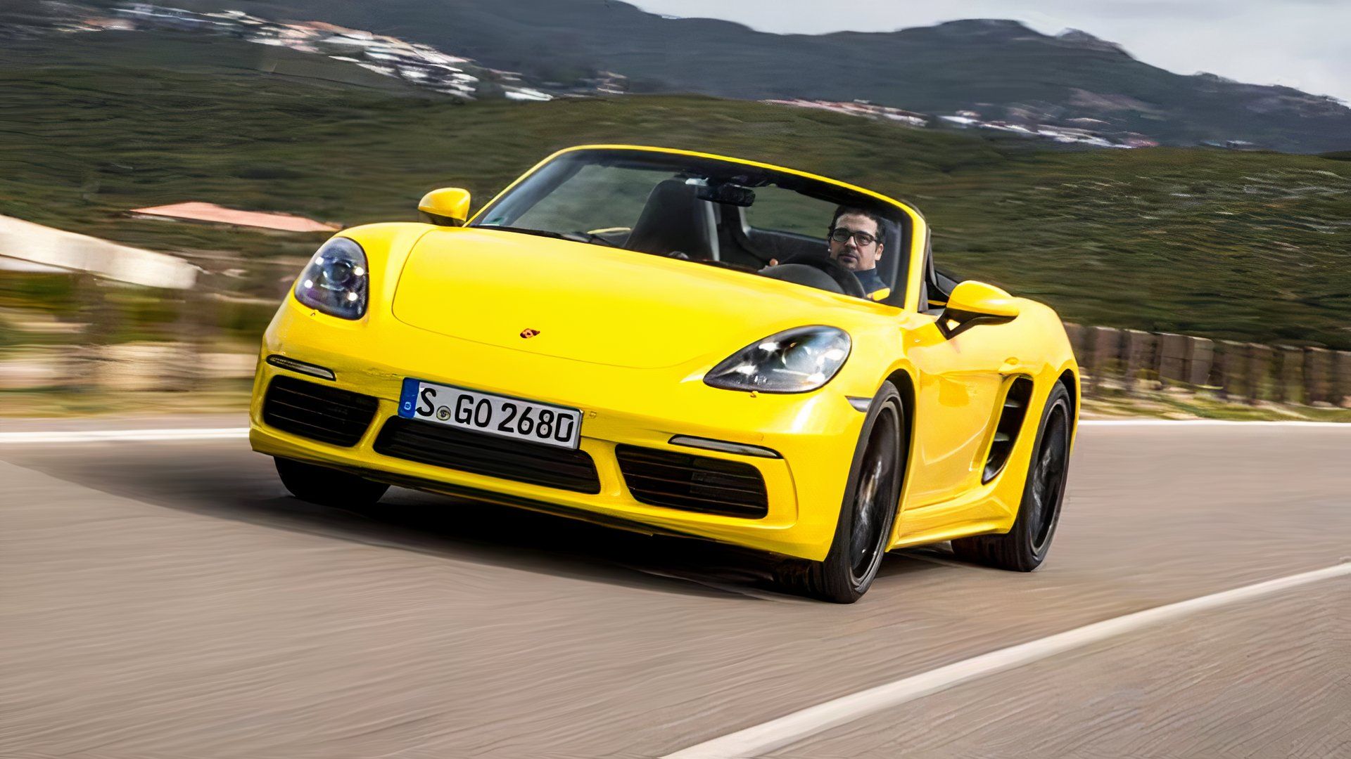 2024 Porsche 718 Boxster em amarelo Dirigindo em estrada de montanha