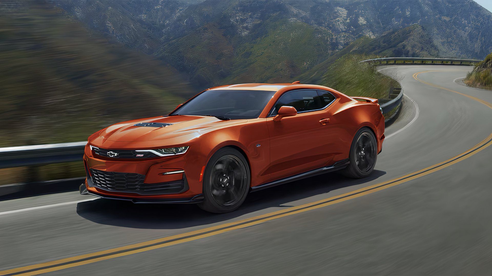 2024 Chevrolet Camaro LT1 in orange and black driving on a country road