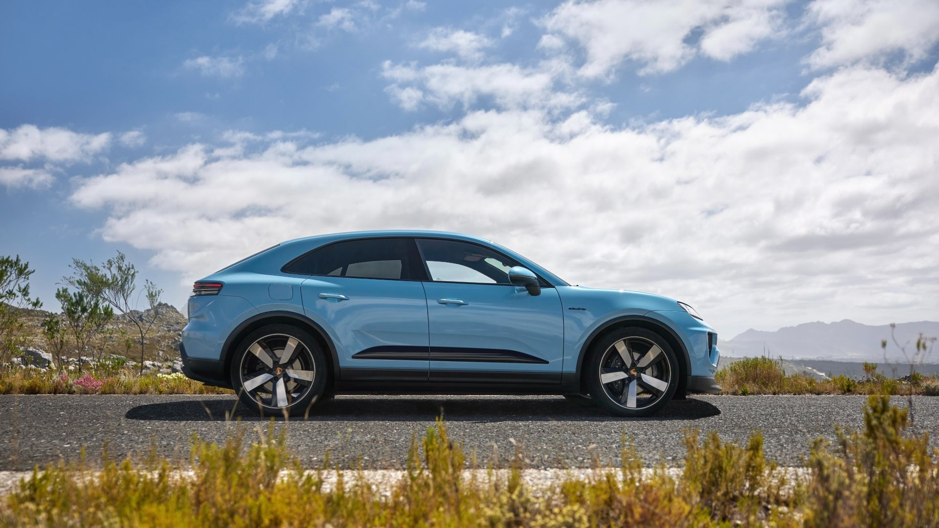 Foto de perfil lateral de um Porsche Macan Electric azul