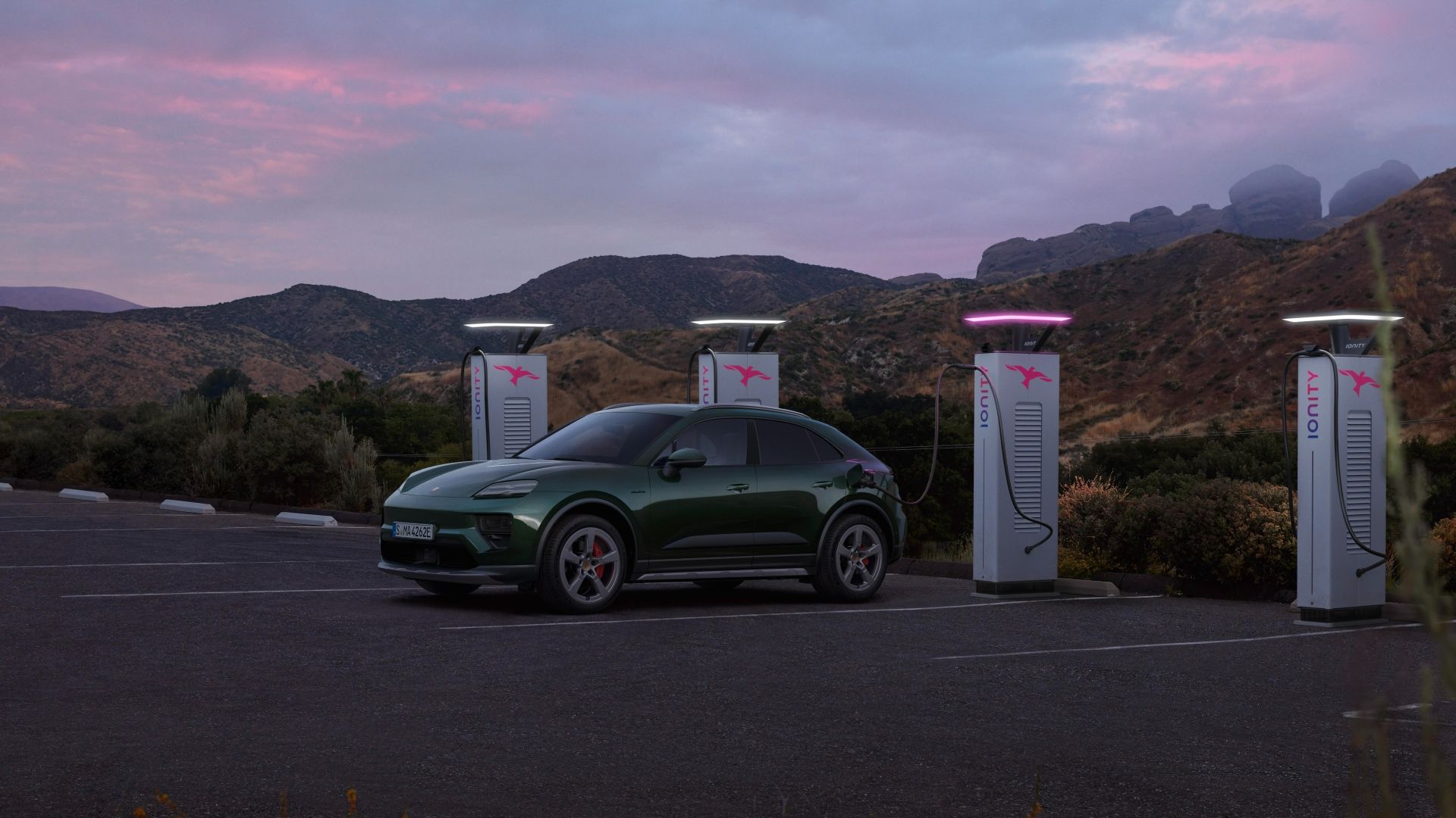 Foto frontal de três quartos de um Porsche Macan Electric carregando em uma estação de carregamento pública Ionity